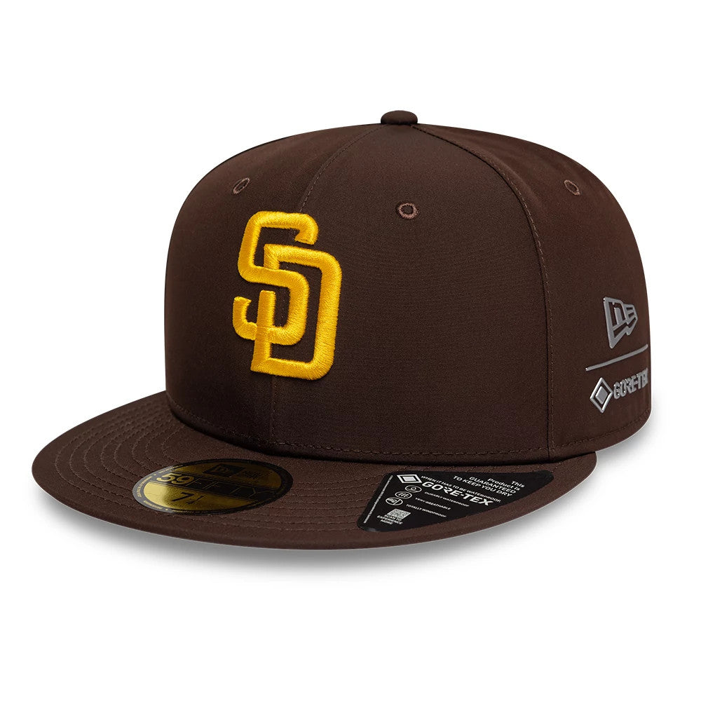 San Diego Padres MLB Gore-Tex Dark Brown New Era 59FIFTY Fitted Cap, three-quarter view showing the raised yellow SD logo on the front panel, brown visor with a gold 59FIFTY size sticker, and New Era flag and Gore-Tex logos on the left side.