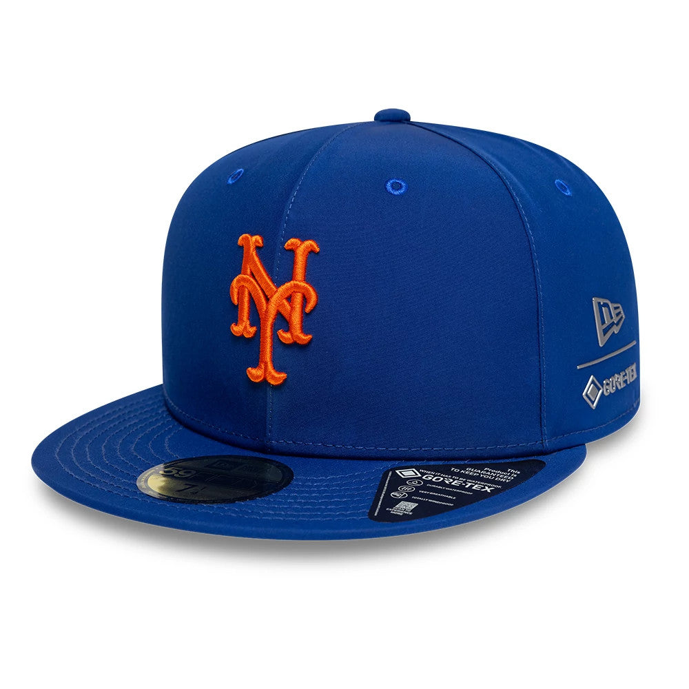 New York Mets MLB Gore-Tex Blue New Era 59FIFTY Fitted Cap, front view showing the orange raised embroidery Mets logo on the structured blue crown, with a gold 59FIFTY size sticker on the blue flat visor.