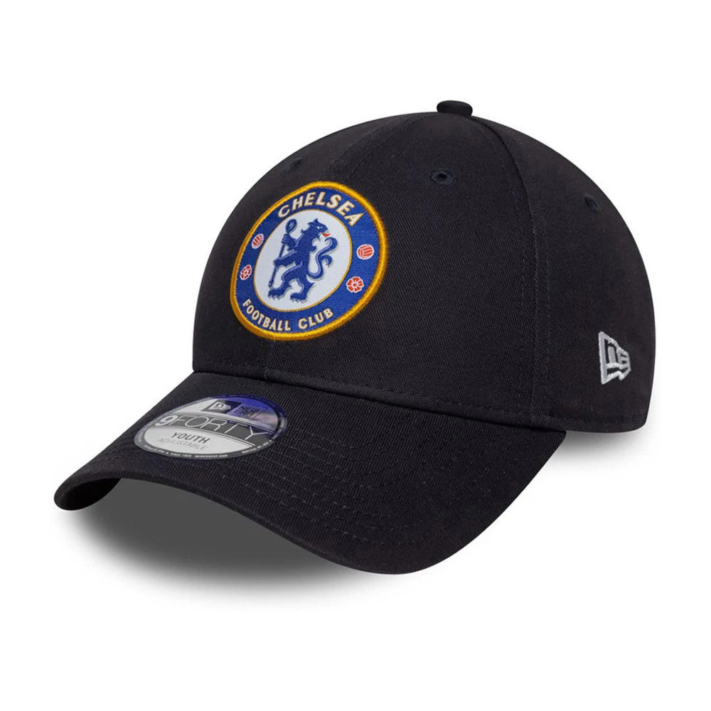 Chelsea FC Lion Crest Youth Core Blue New Era 9FORTY Cap, three-quarter view showing the raised embroidered lion crest logo on the front panel, a curved blue visor with a 9FORTY size sticker, and a grey New Era flag logo on the left side.