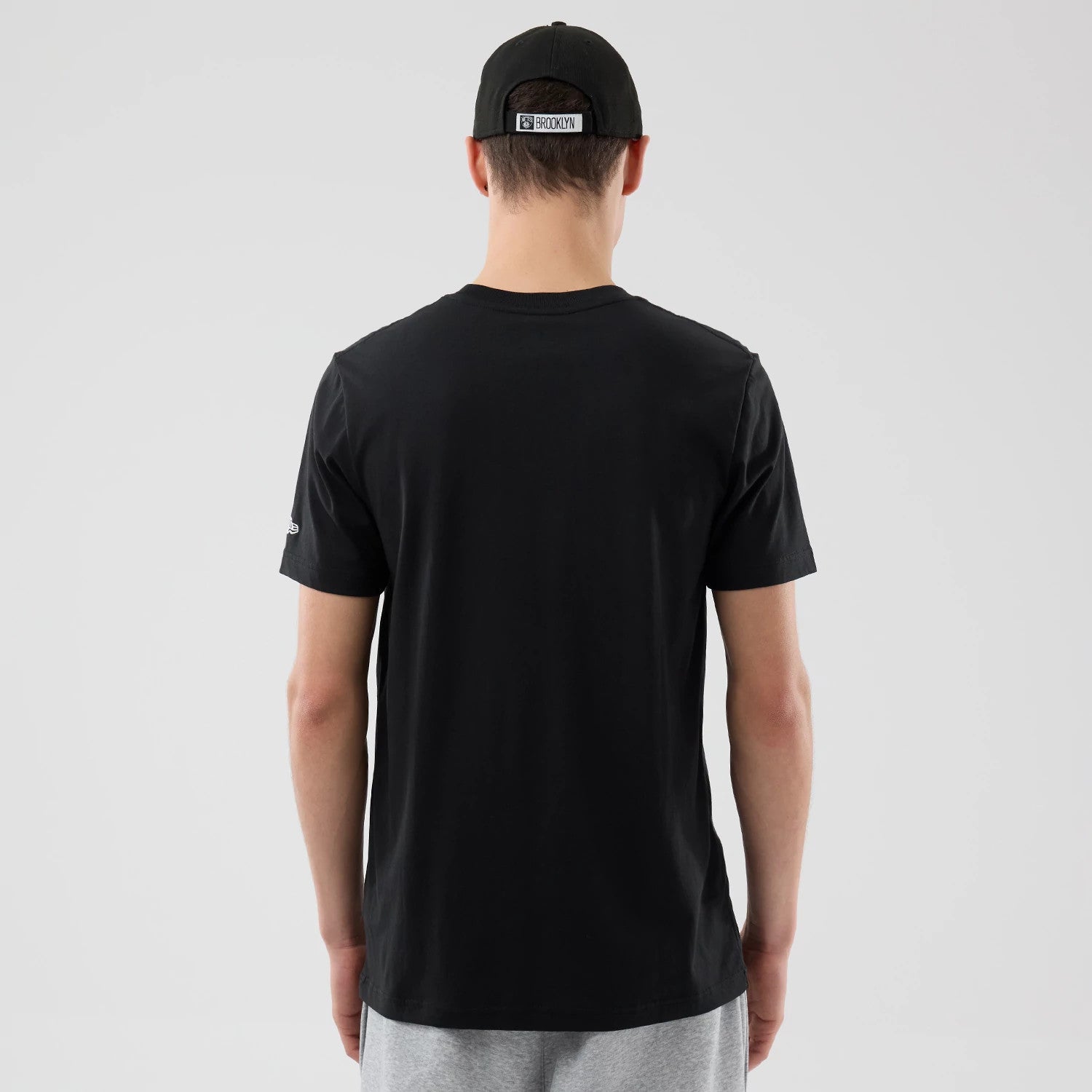 The Male model is wearing Brooklyn Nets NBA City Edition Black T-Shirt 2