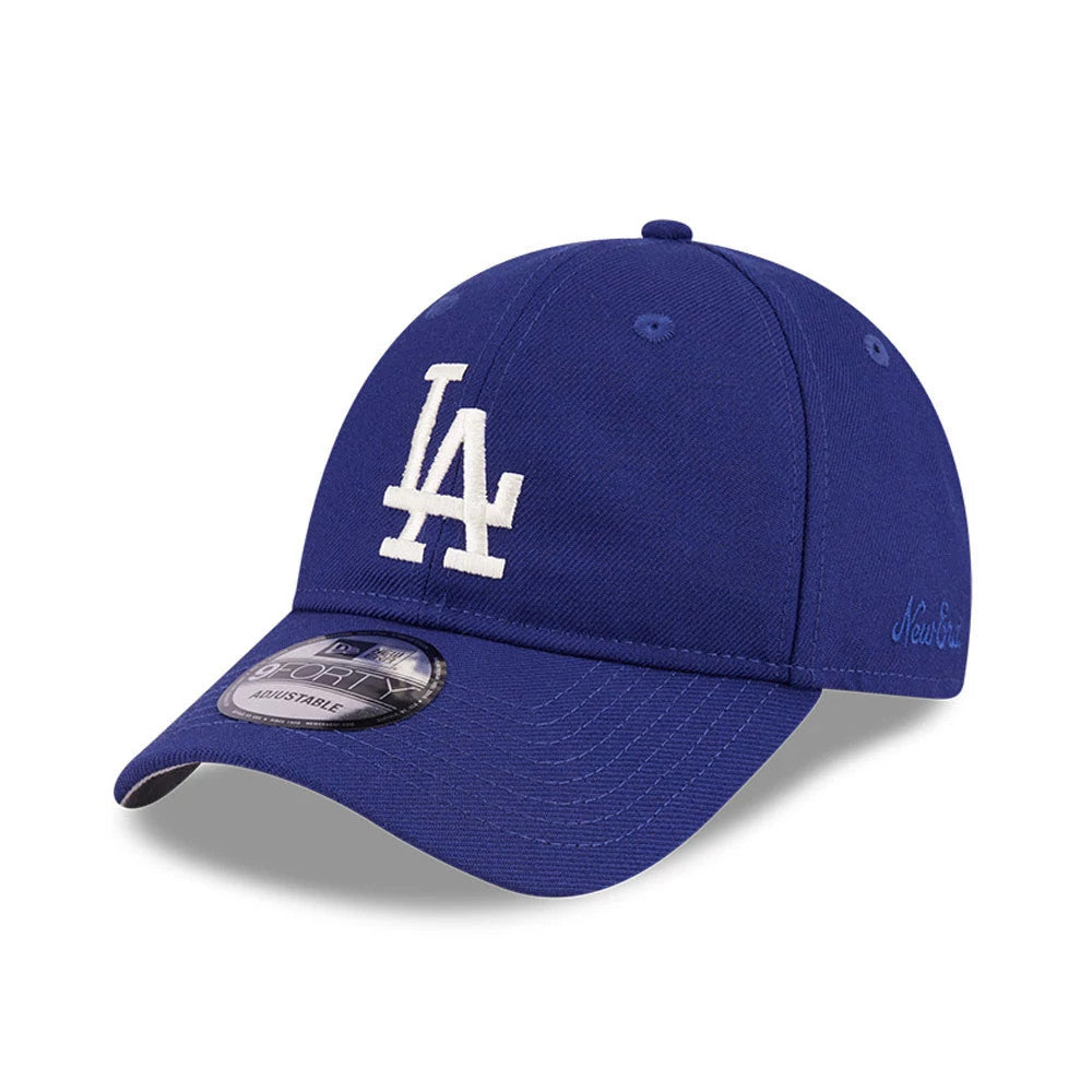 LA Dodgers FOG X MLB Dark Blue New Era 9FORTY Adjustable Cap, three-quarter view showing the raised white LA logo on the structured crown, curved dark blue visor with a 9FORTY size sticker, and New Era flag logo on the left side.