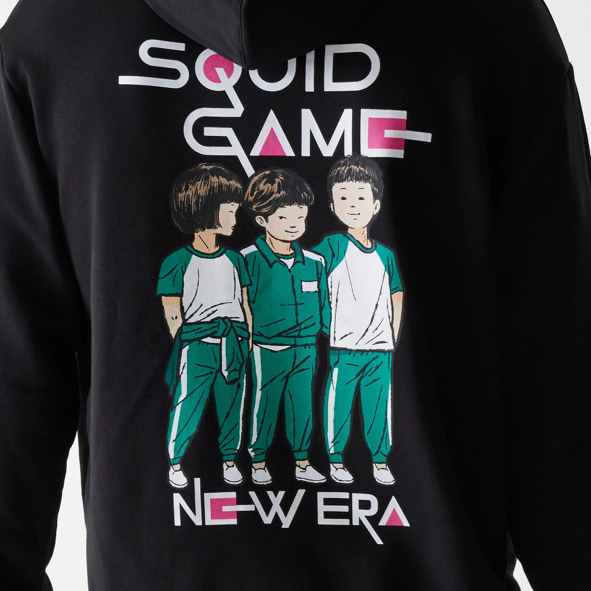 New Era Netflix Squid Game Black Oversized Pullover Hoodie, back view showing a large printed graphic of three characters in turquoise and white outfits, with Squid Game lettering above and the New Era logo in white and pink below.