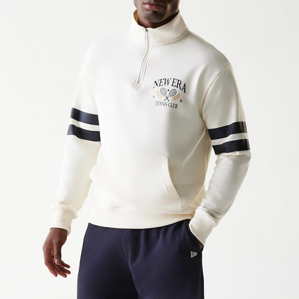 New Era Open White Oversized 1/4 Zip Sweater, front view on a model showing the New Era Tennis Club logo with crossed rackets on the left chest and navy double stripes on the sleeves above a kangaroo pocket.