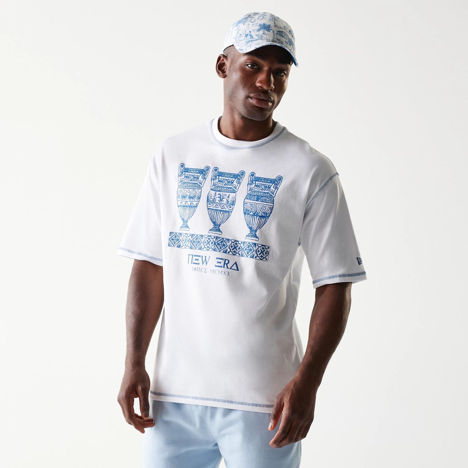 The Male model is wearing New Era Orthodox Vase White Oversized T-Shirt 1