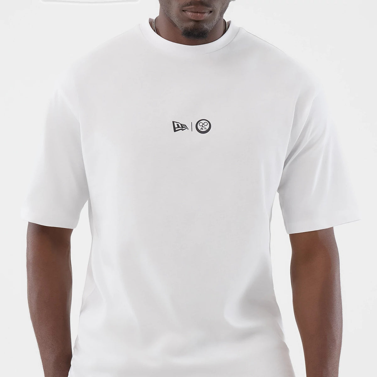 New Era Sakamoto Days Icon Netflix White T-Shirt, front view displaying a clean white design with small black embroidered New Era and Sakamoto Days logos centred on the chest, being worn casually.