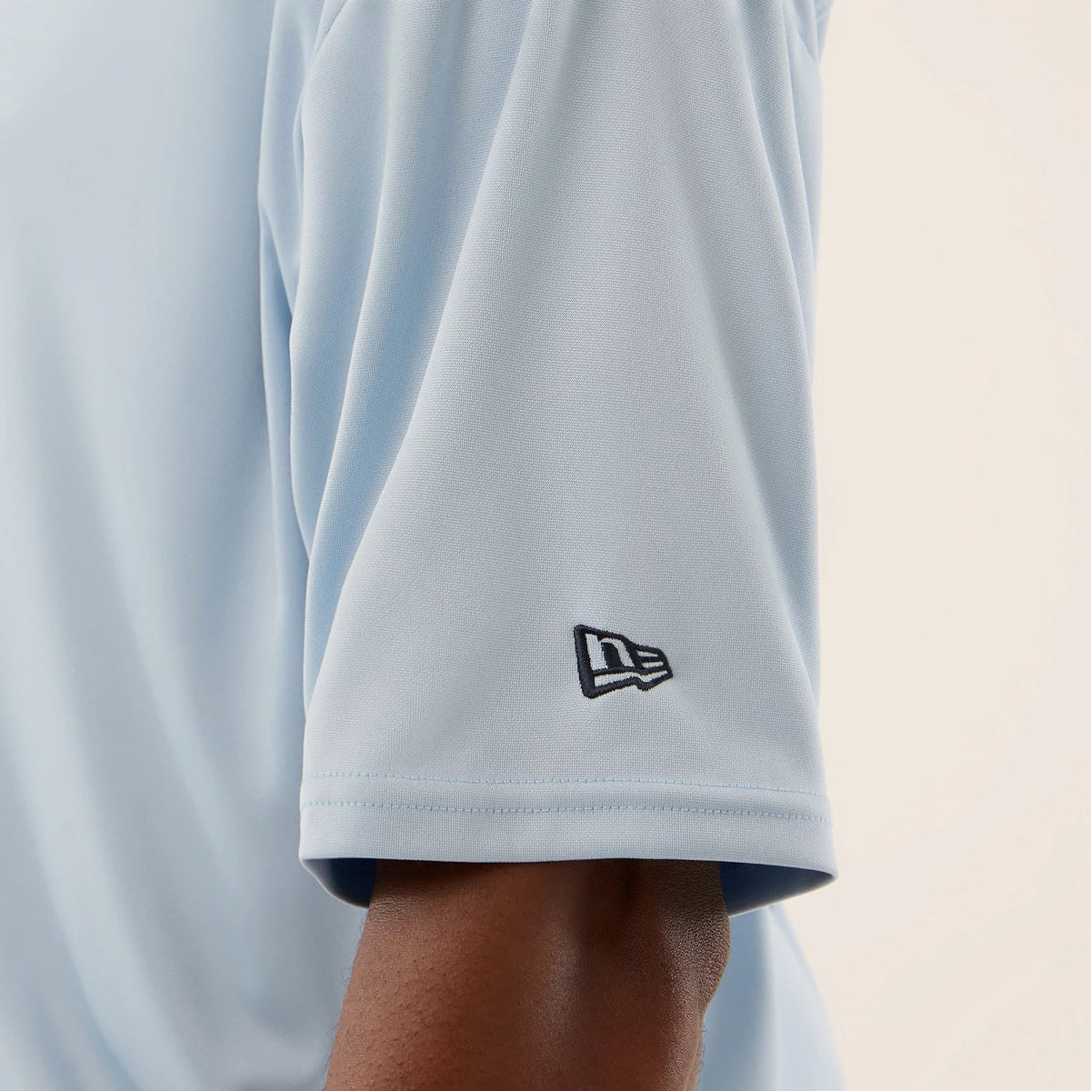 New Era New York Yankees MLB Mesh Infill Pastel Blue Oversized T-Shirt, side view showing the light blue sleeve with a small black embroidered New Era logo near the cuff, highlighting the relaxed fit over the arm.