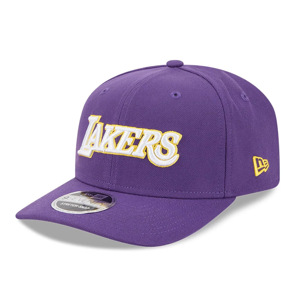 LA Lakers NBA Statement Purple New Era 9SEVENTY Stretch Snap Adjustable Cap, front view showing the raised white and gold embroidered Lakers logo on the front panel, with a purple visor and a 9SEVENTY size sticker.