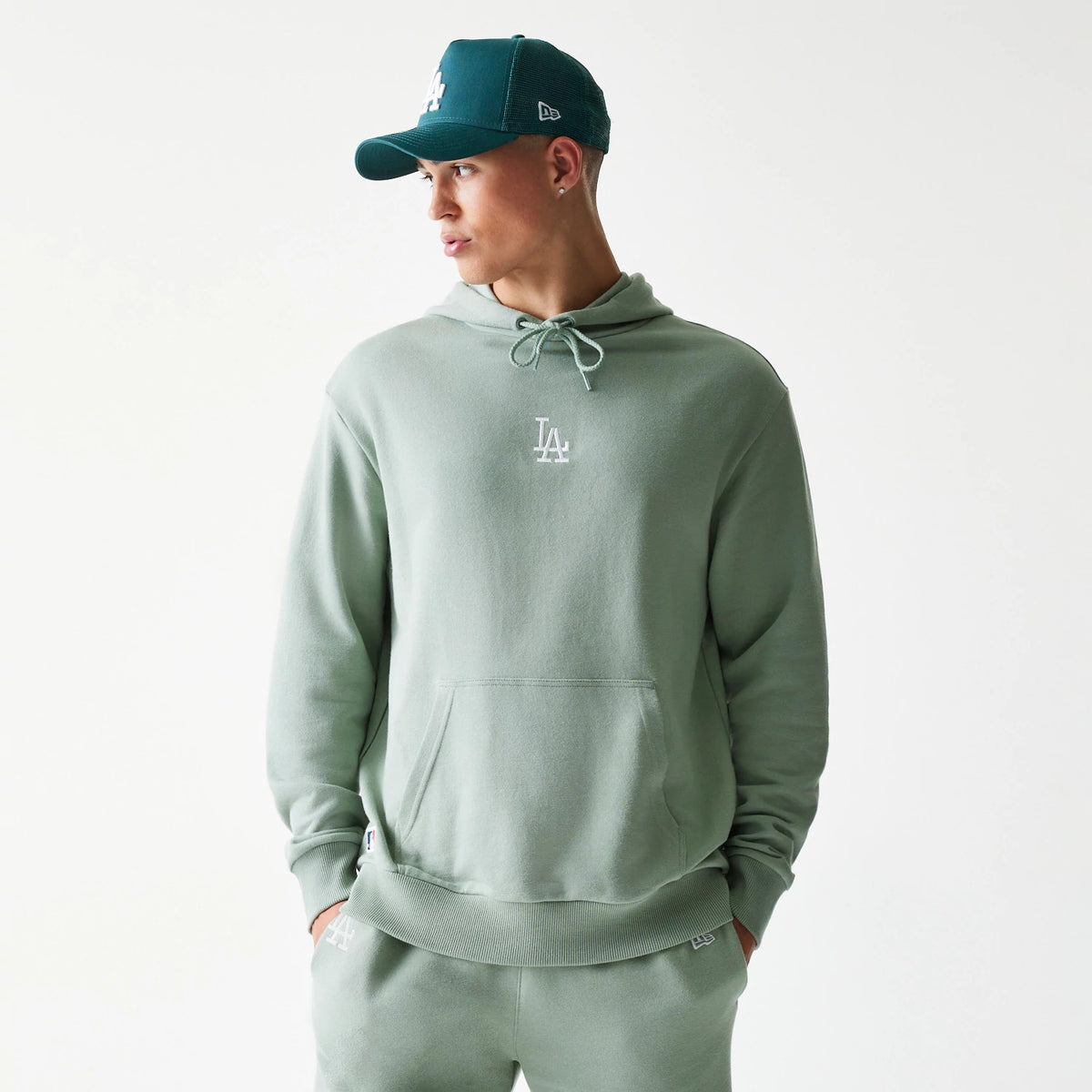 New Era LA Dodgers MLB Midi Pastel Green Oversized Pullover Hoodie, front view on-model showing the small white embroidered LA logo at the centre of the chest, drawstring hood and a kangaroo pocket at the waist.