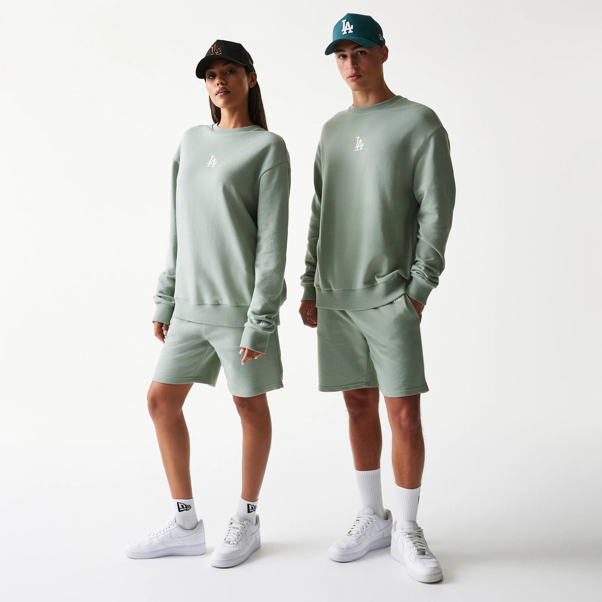 New Era LA Dodgers MLB Midi Pastel Green Oversized Crew Neck Sweater, front view on models wearing matching pastel shorts and white sneakers, featuring a white LA embroidered logo on the centre of the chest.