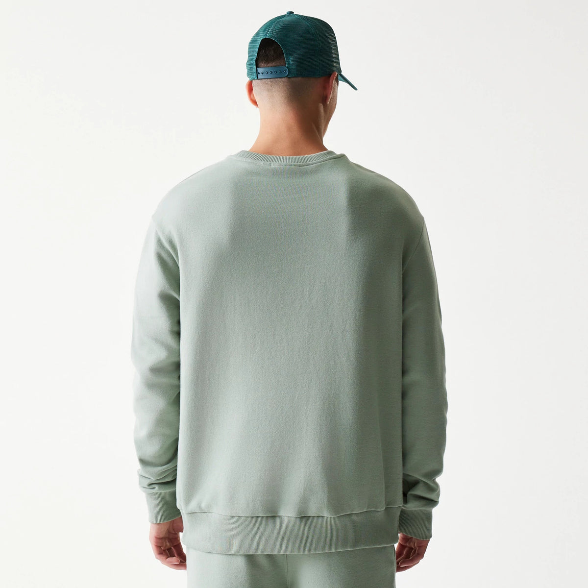 New Era LA Dodgers MLB Midi Pastel Green Oversized Crew Neck Sweater, back view on a model showing the relaxed fit of the pastel green fabric and the ribbed collar and hem, paired with matching pastel green trousers.