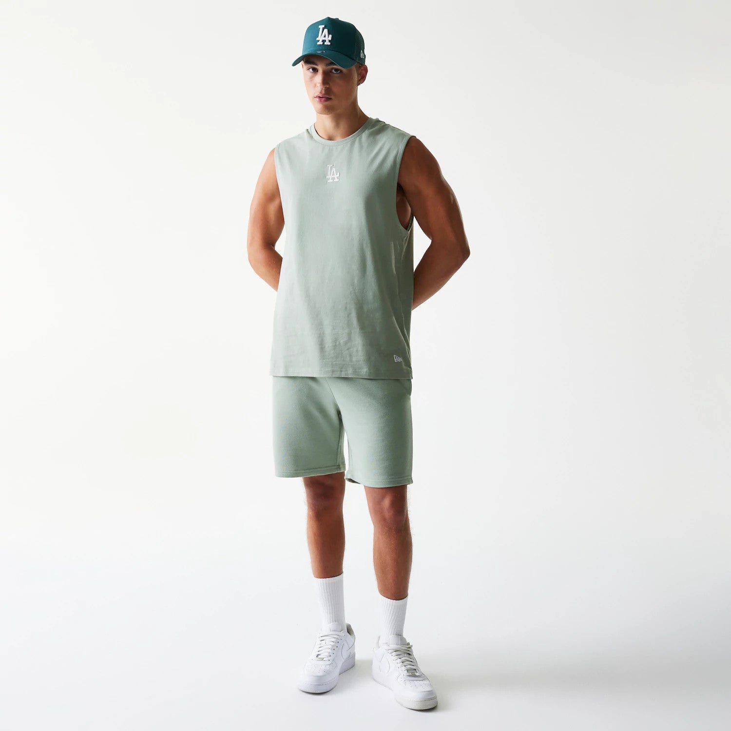 New Era LA Dodgers MLB Pastel Green Sleeveless T-Shirt, front view on a model paired with matching shorts and a cap, featuring an embroidered LA logo centred on the chest and a small embroidered New Era logo near the lower left hem.