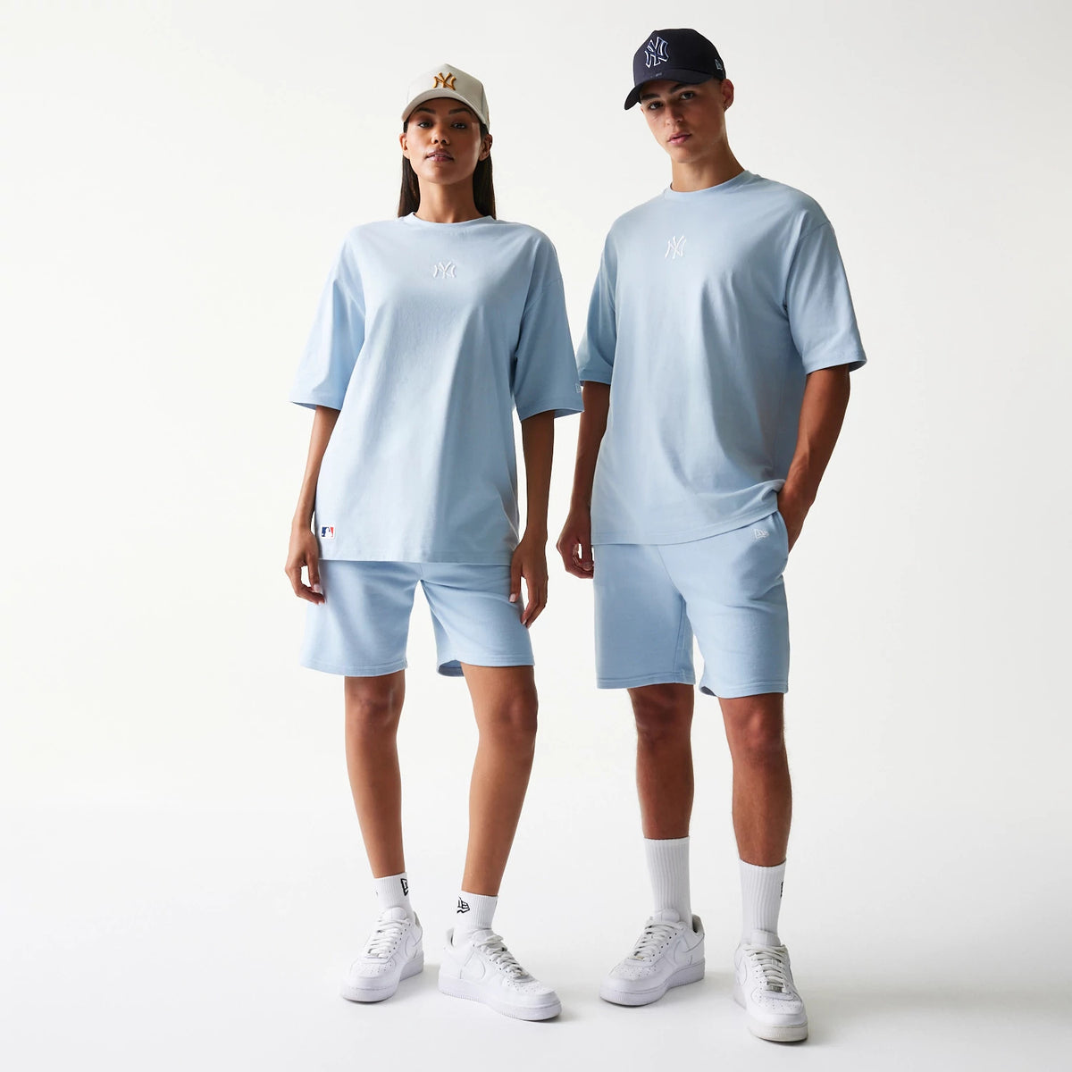 New Era New York Yankees MLB Midi Pastel Blue Oversized T-Shirt, front view on-model showcasing a light blue oversized fit with a white embroidered Yankees logo on the chest, styled with matching shorts and white trainers.