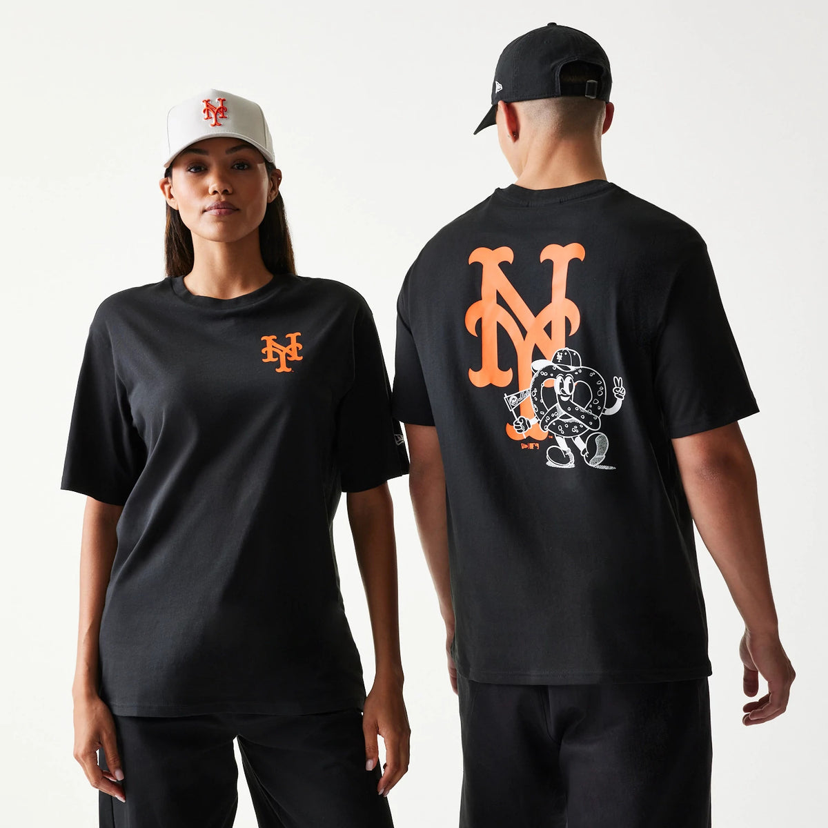New Era New York Mets MLB Food Graphic Black T-Shirt, front and back view on models with caps, showing an orange embroidered NY logo on the chest and a large graphic of a pretzel character with an oversized NY logo printed on the back.