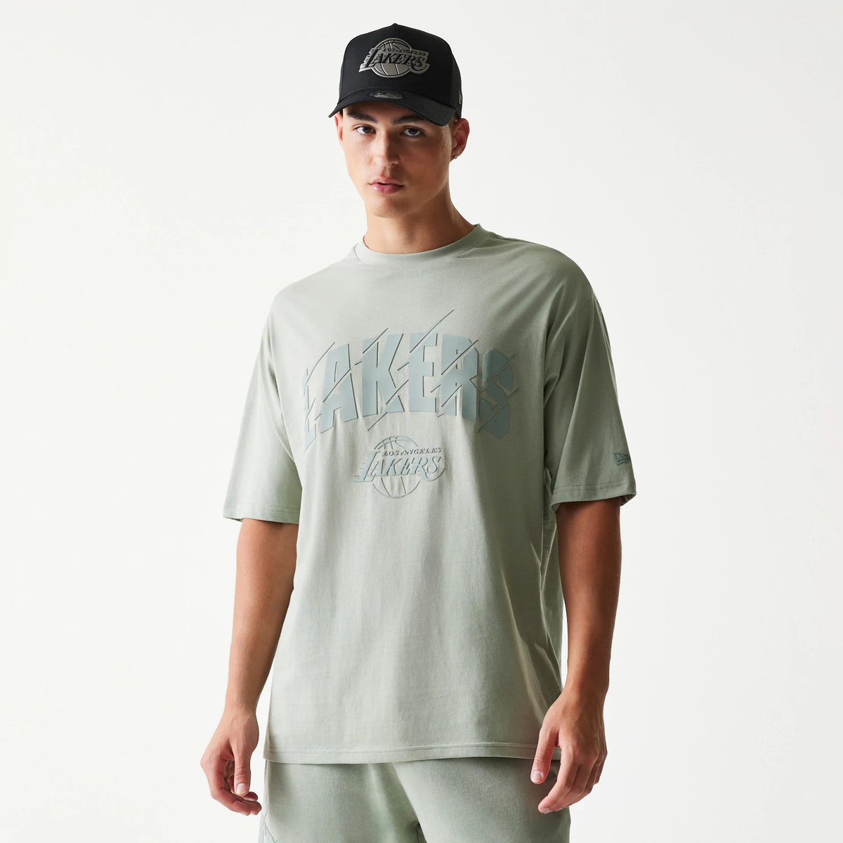 New Era LA Lakers NBA Pastel Green Oversized T-Shirt, front view on-model showing the large LA Lakers graphic across the chest in matching colours and an embroidered New Era logo on the left sleeve.