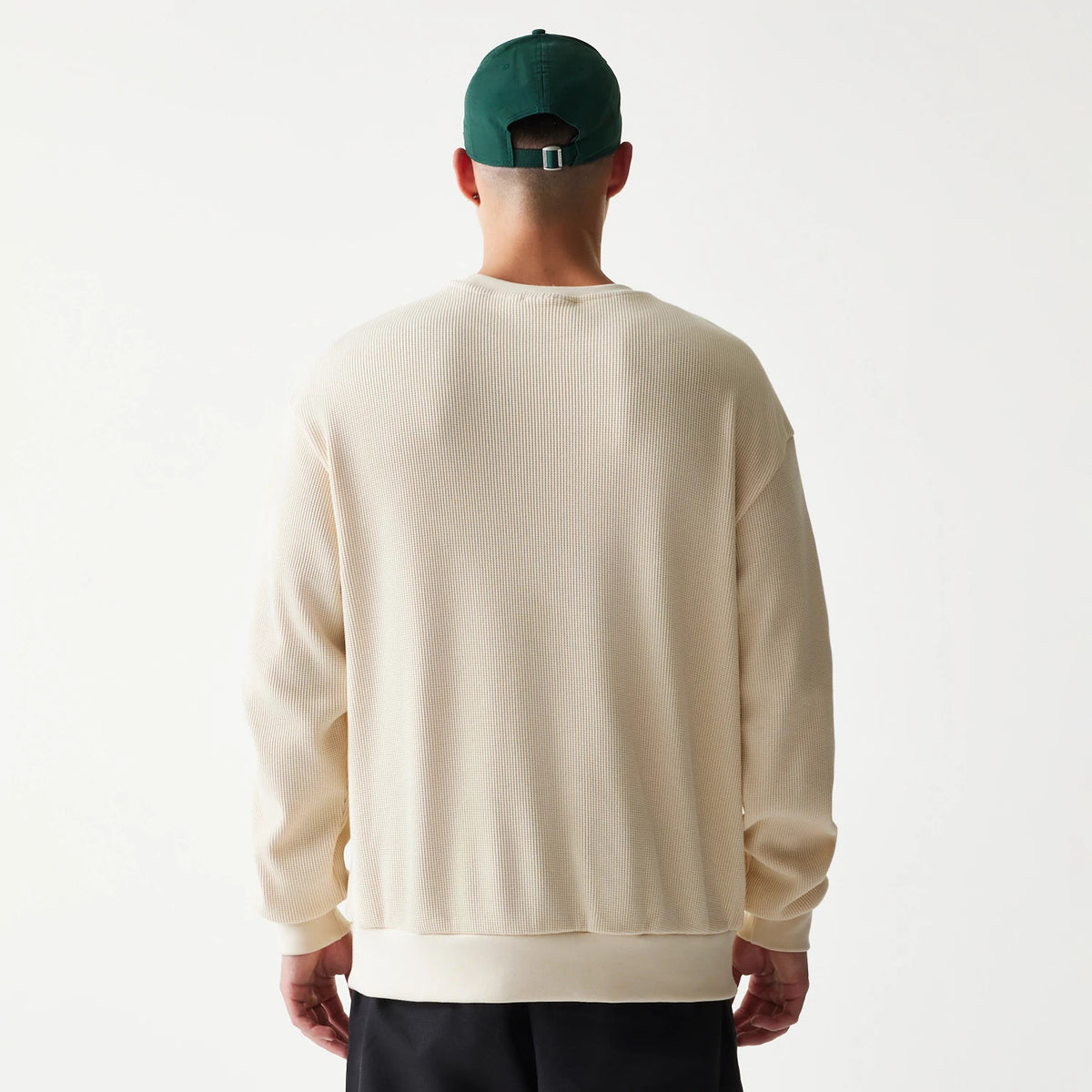 The model is wearing this New Era Script Waffle Crew Neck Sweater in light beige. 2