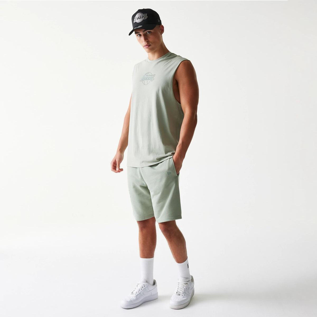 New Era LA Lakers NBA Pastel Green Sleeveless T-Shirt, front view on-model showing a embroidered LA Lakers logo in the centre of the chest, paired with matching pastel green shorts and a contrasting black cap.