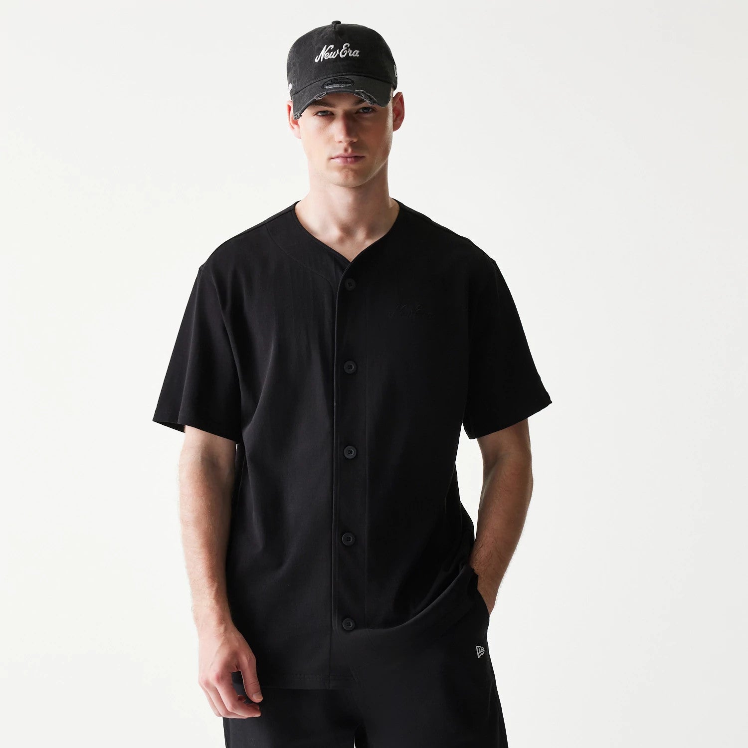 The model is wearing this New Era Open Heritage Script T-Shirt in black. 1