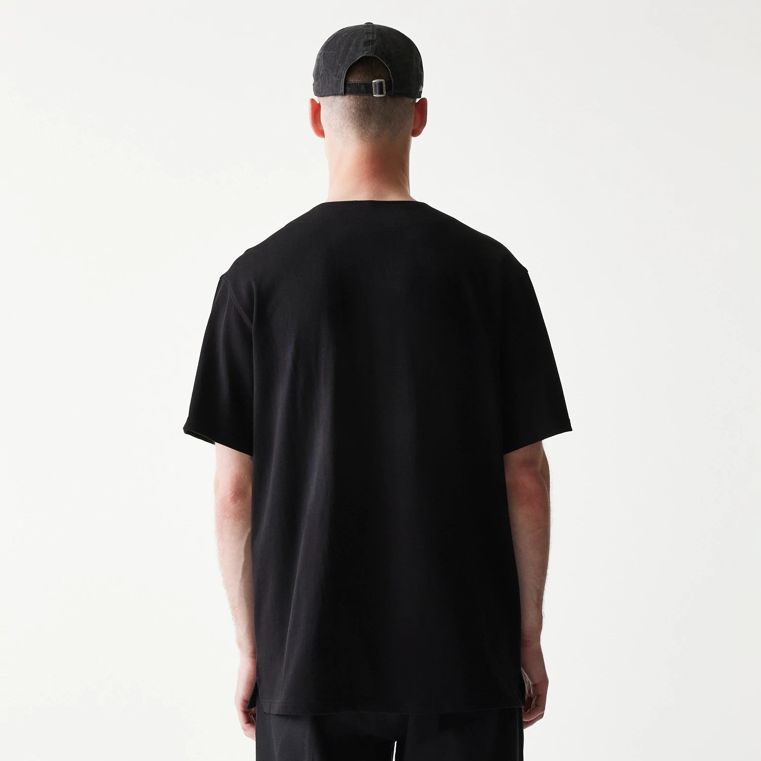 The model is wearing this New Era Open Heritage Script T-Shirt in black. 2