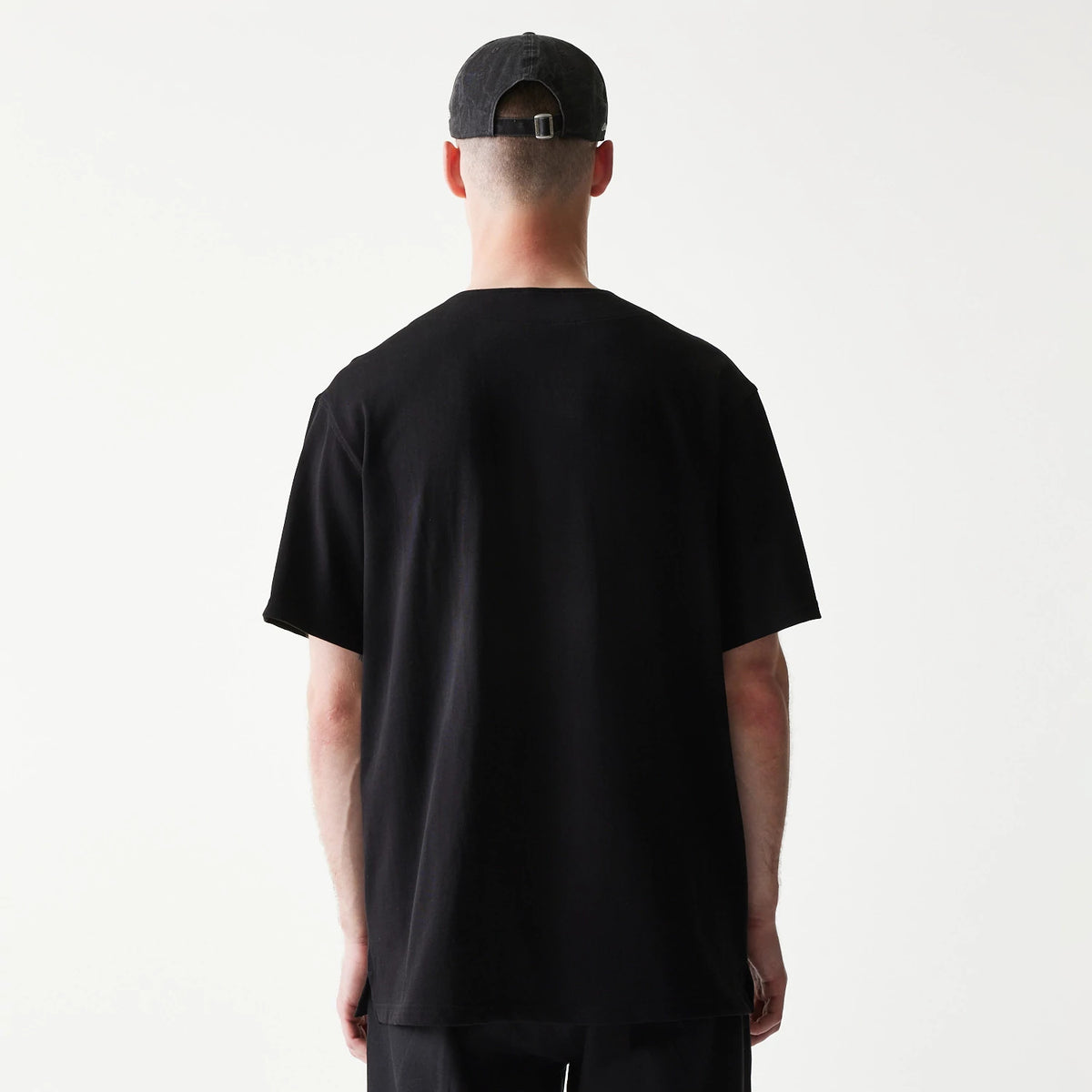 The model is wearing this New Era Open Heritage Script T-Shirt in black. 2