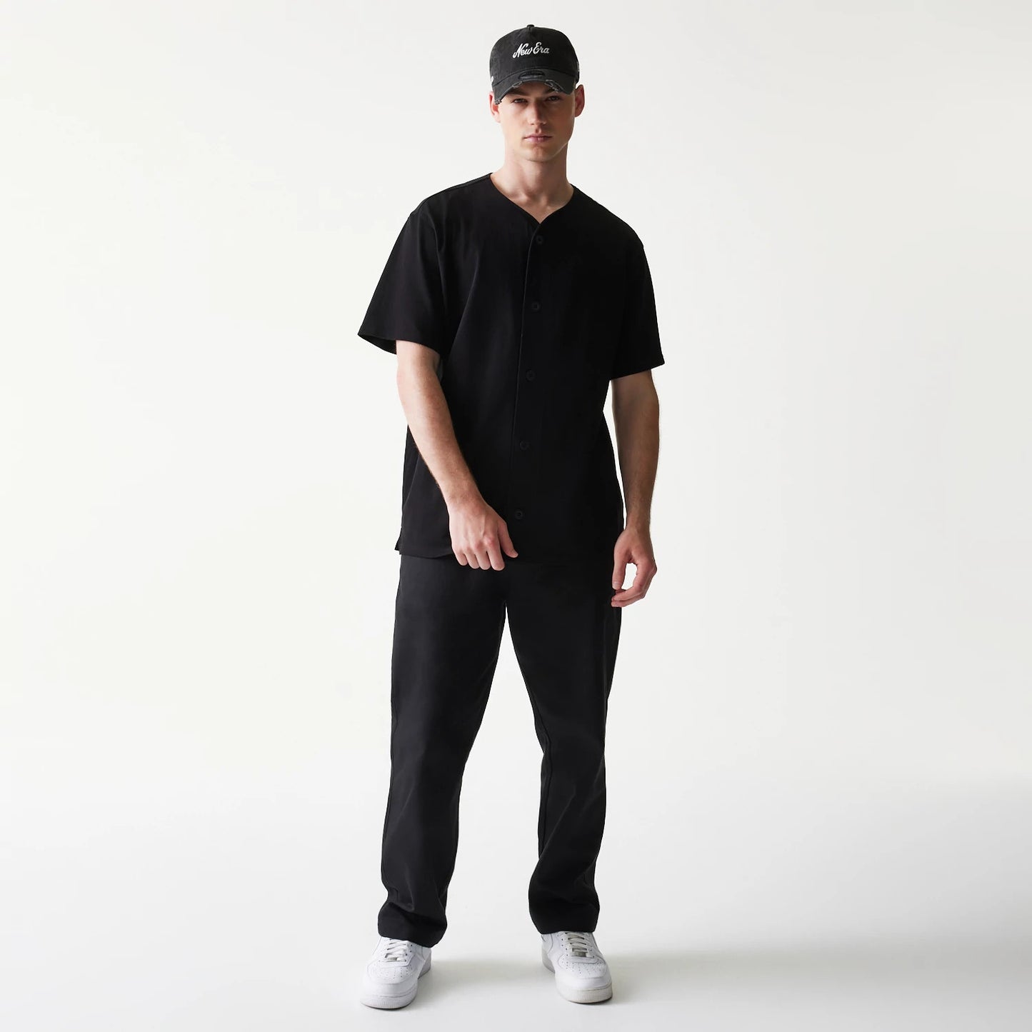 The model is wearing this New Era Open Heritage Script T-Shirt in black. 8