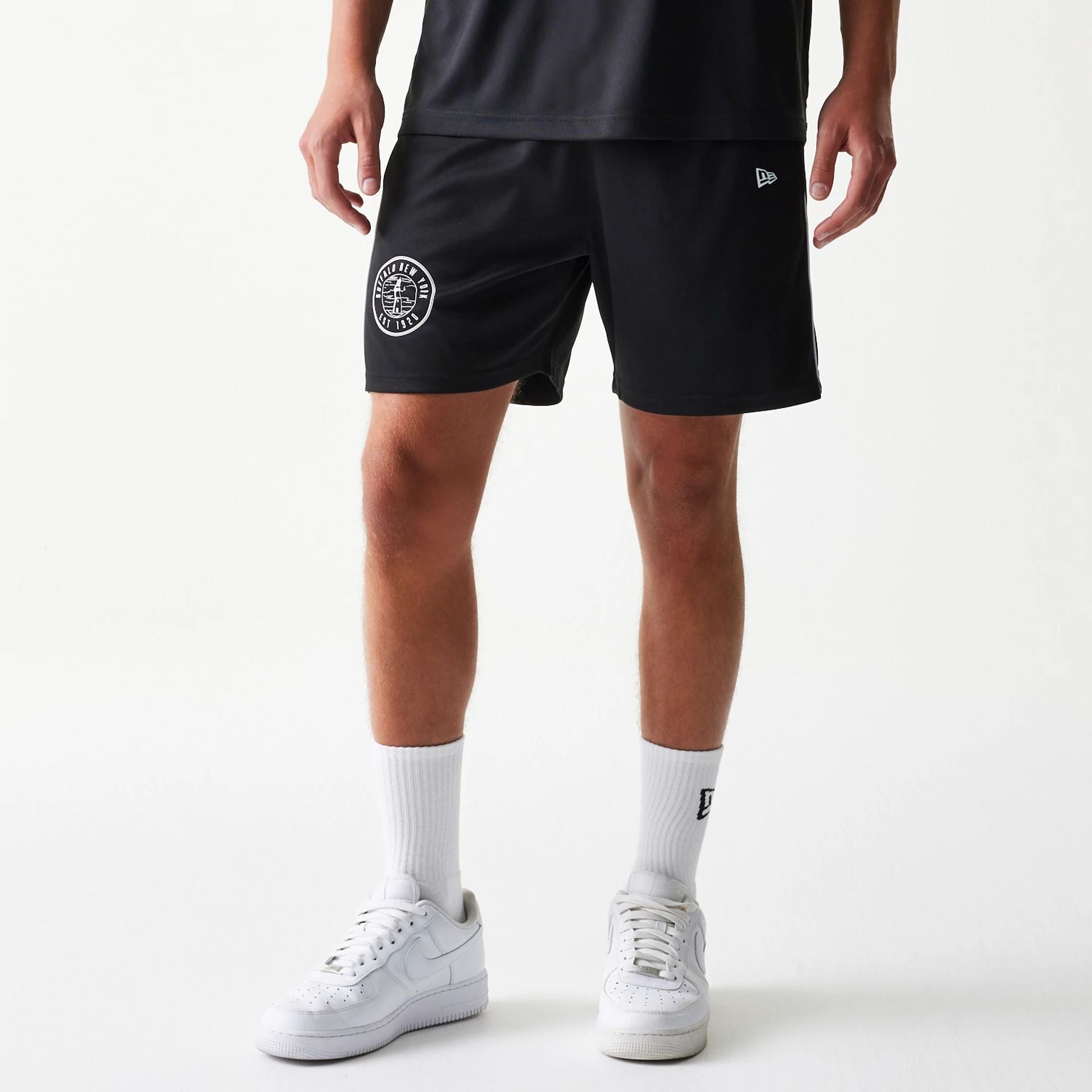 The model is wearing this New Era Football Shorts in black. 1