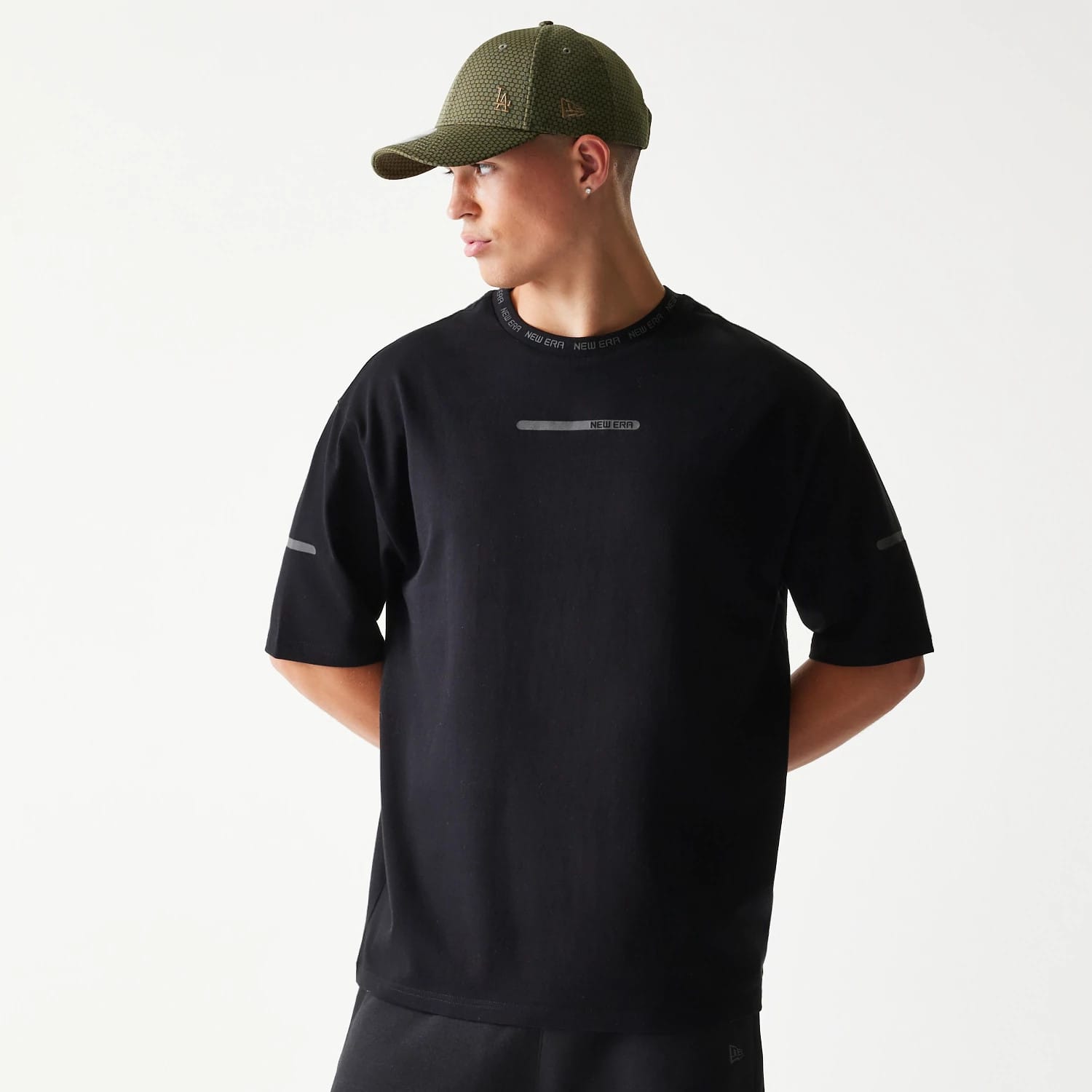 The model is wearing this New Era Tech Oversized T-Shirt in black. 1
