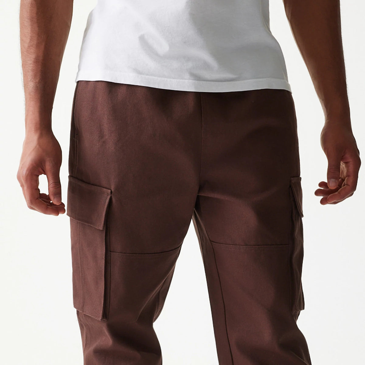 New Era Brown Straight Leg Cargo Joggers, rear view with cargo pockets on both legs and a straight leg silhouette, made of soft brown fabric, showcased on a model wearing a white t-shirt.