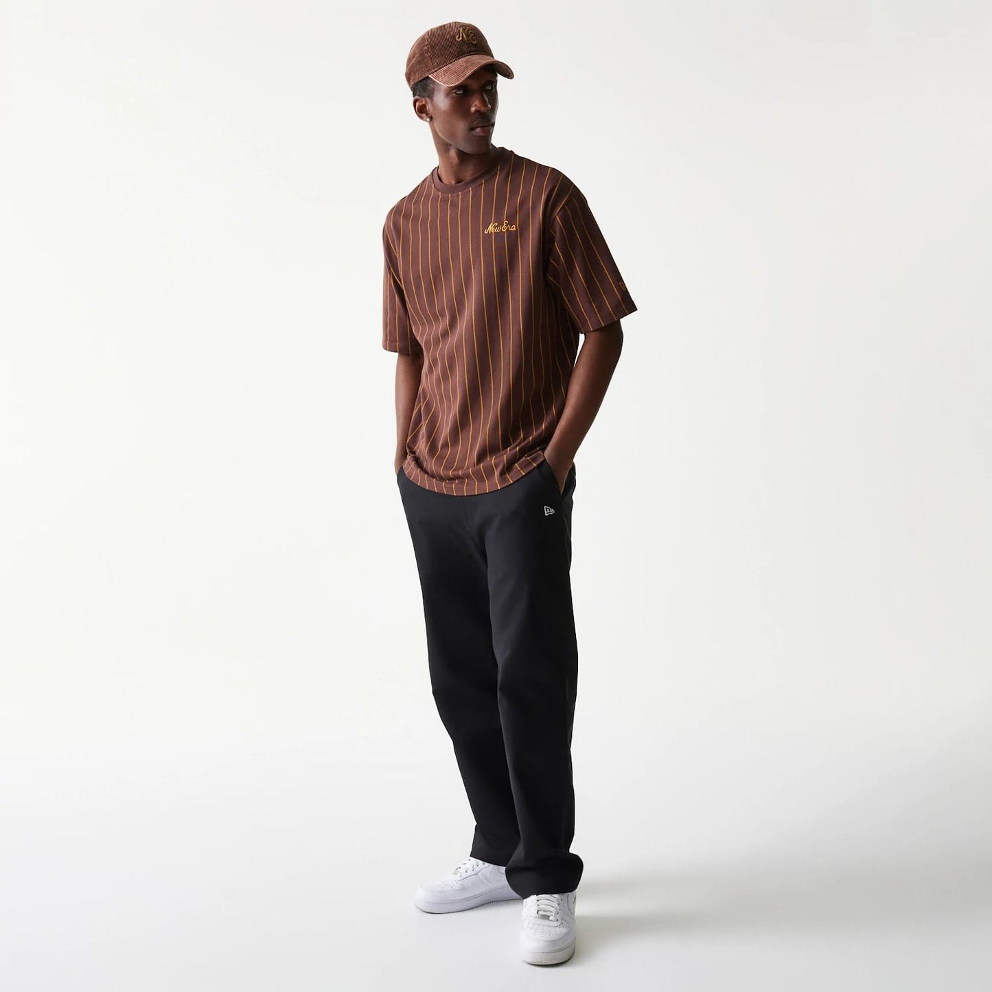 The model is wearing this New Era Pinstripe Oversized T-Shirt in brown. 8