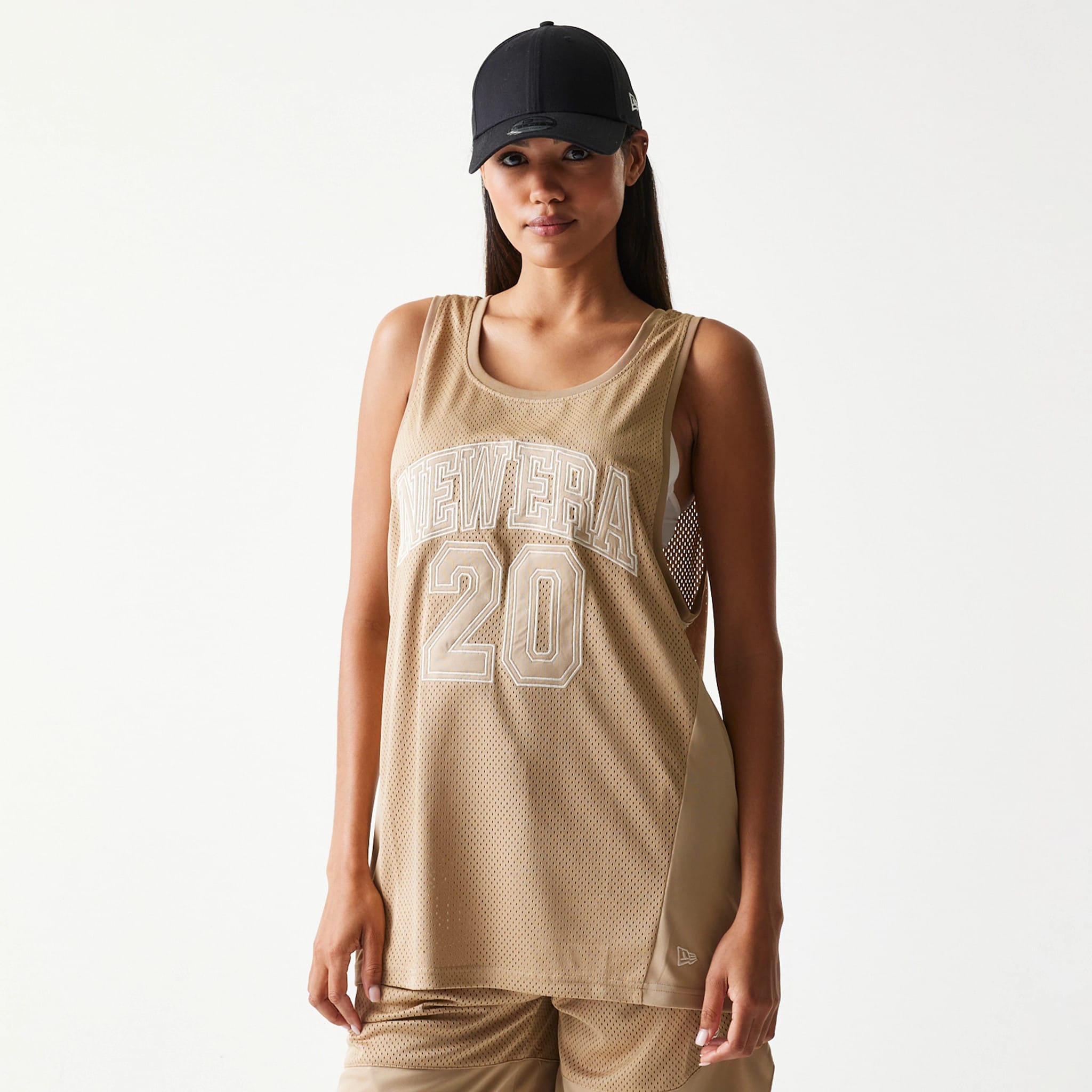 The model is wearing this New Era Mesh Tank Top in light beige. 4