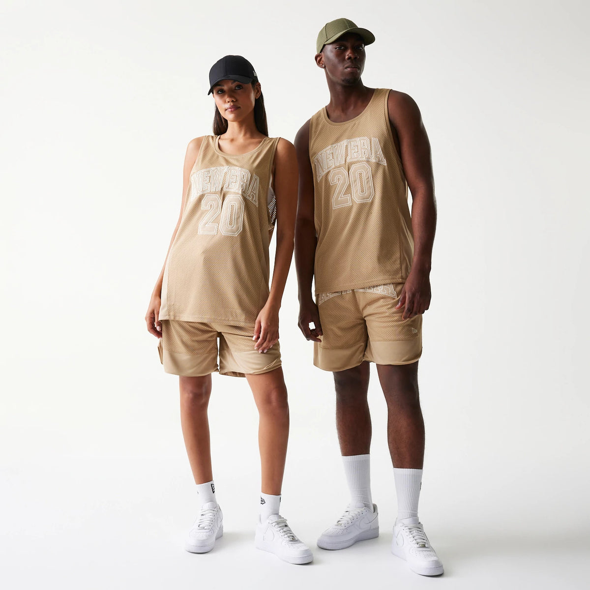 New Era Mesh Light Beige Tank Top, front view on models wearing matching shorts and caps, featuring large white New Era and number 20 embroidery across the chest on the light beige mesh fabric.