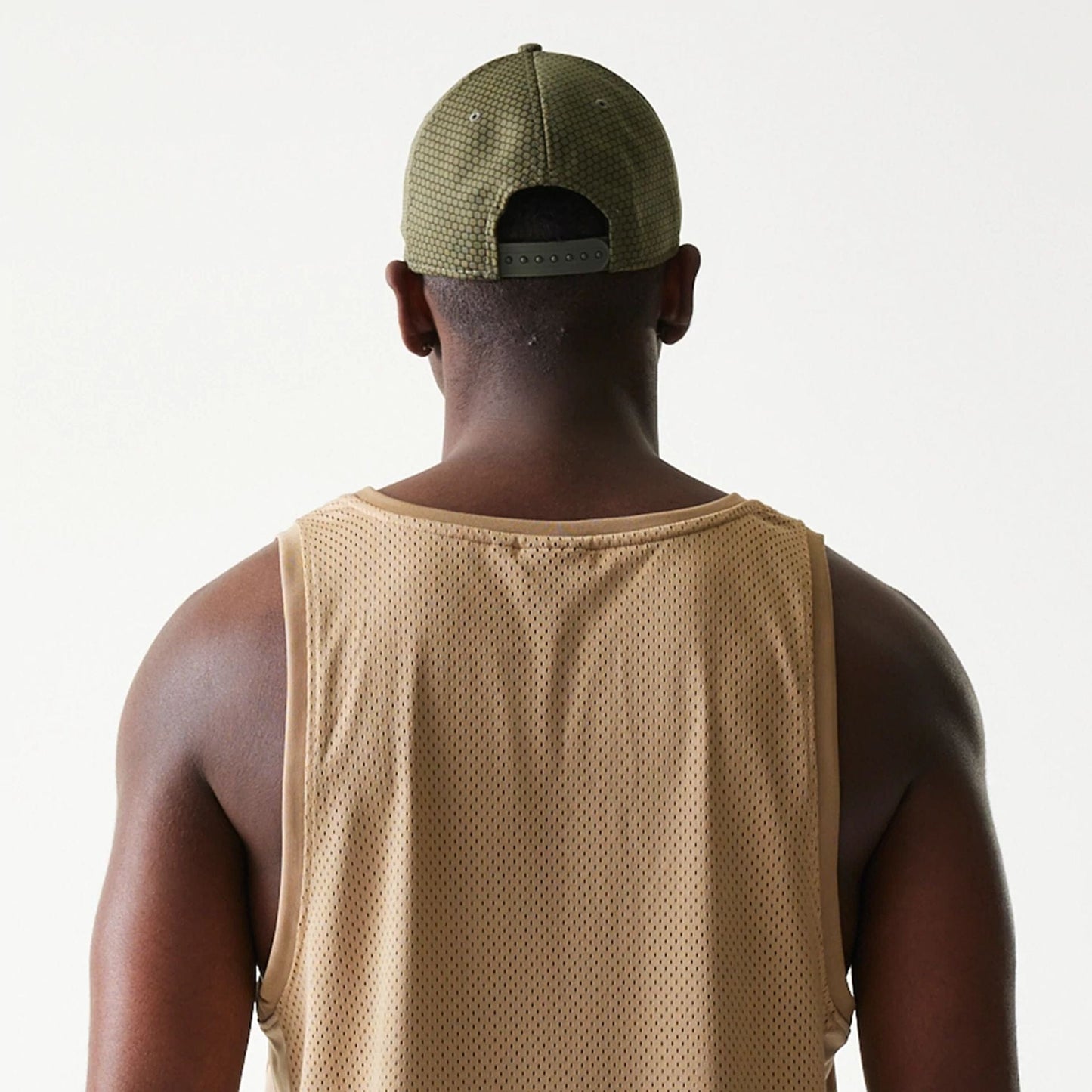 The model is wearing this New Era Mesh Tank Top in light beige. 8