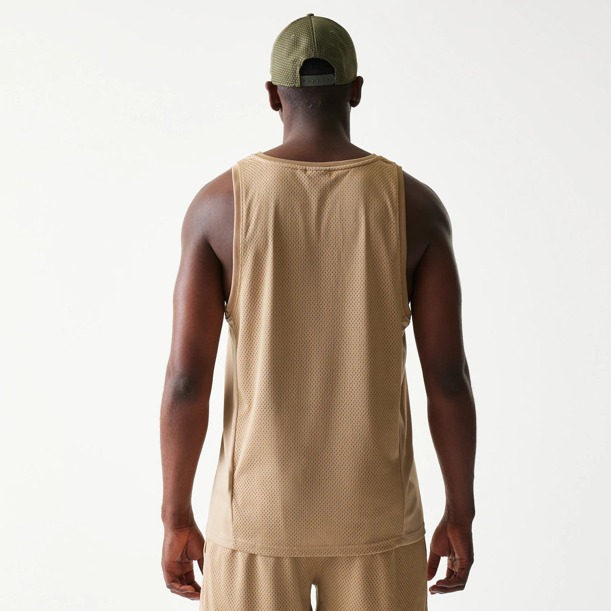 New Era Mesh Light Beige Tank Top, back view on a model showing the texture of the light beige mesh fabric and relaxed fit across the shoulders and waist for a casual athletic look.