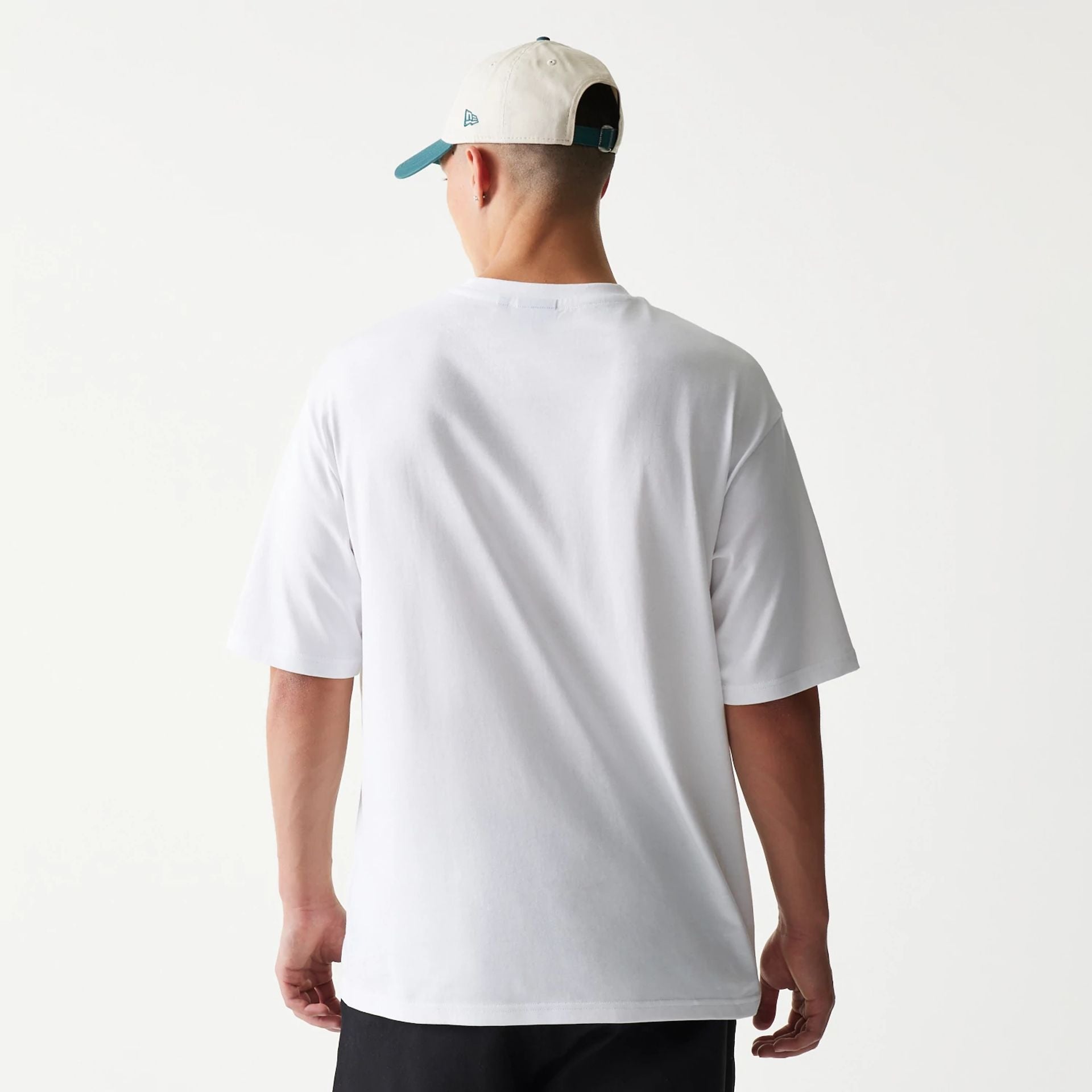 The model is wearing this New Era Baseball Player Graphic Oversized T-Shirt in white. 2