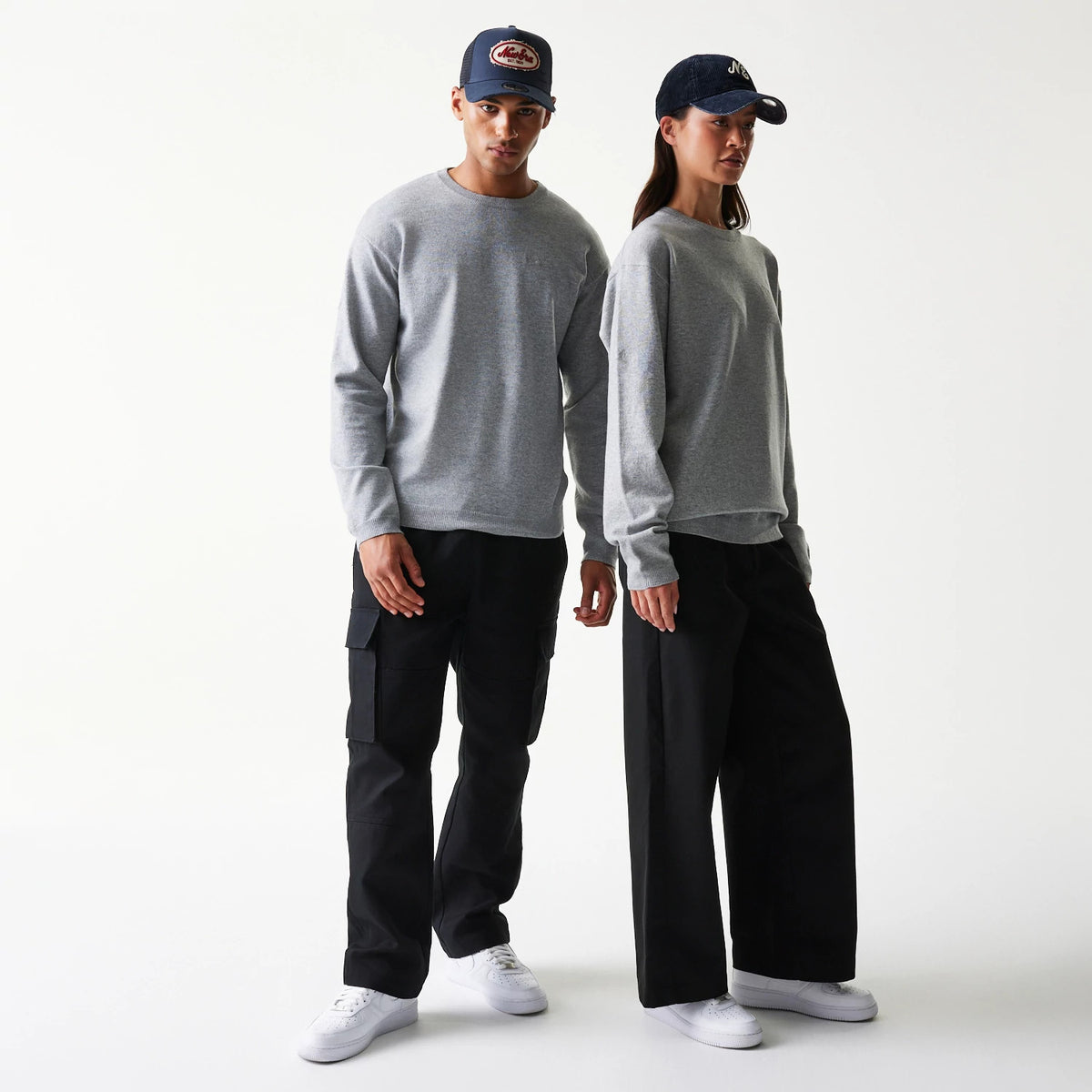 New Era Essential Flag Grey Knitted Sweater, front view on a model with a grey crew neck and long sleeves, worn with black trousers and white trainers, highlighting the simple knit pattern.