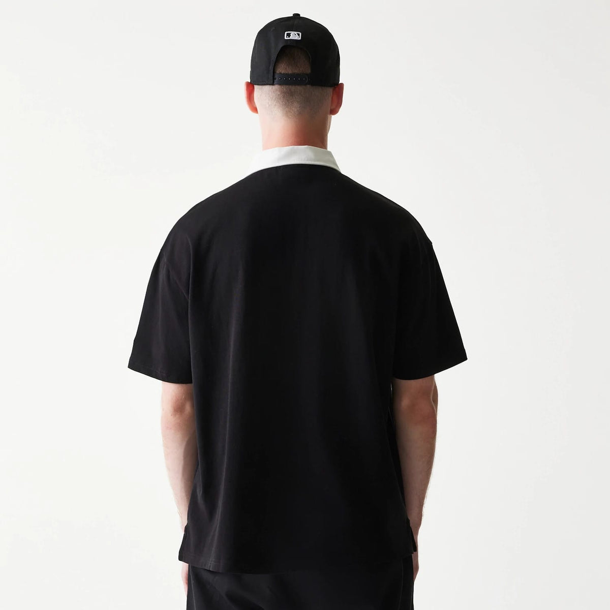 The model is wearing this MLB New York Yankees Oversized Polo T-Shirt in black. 2