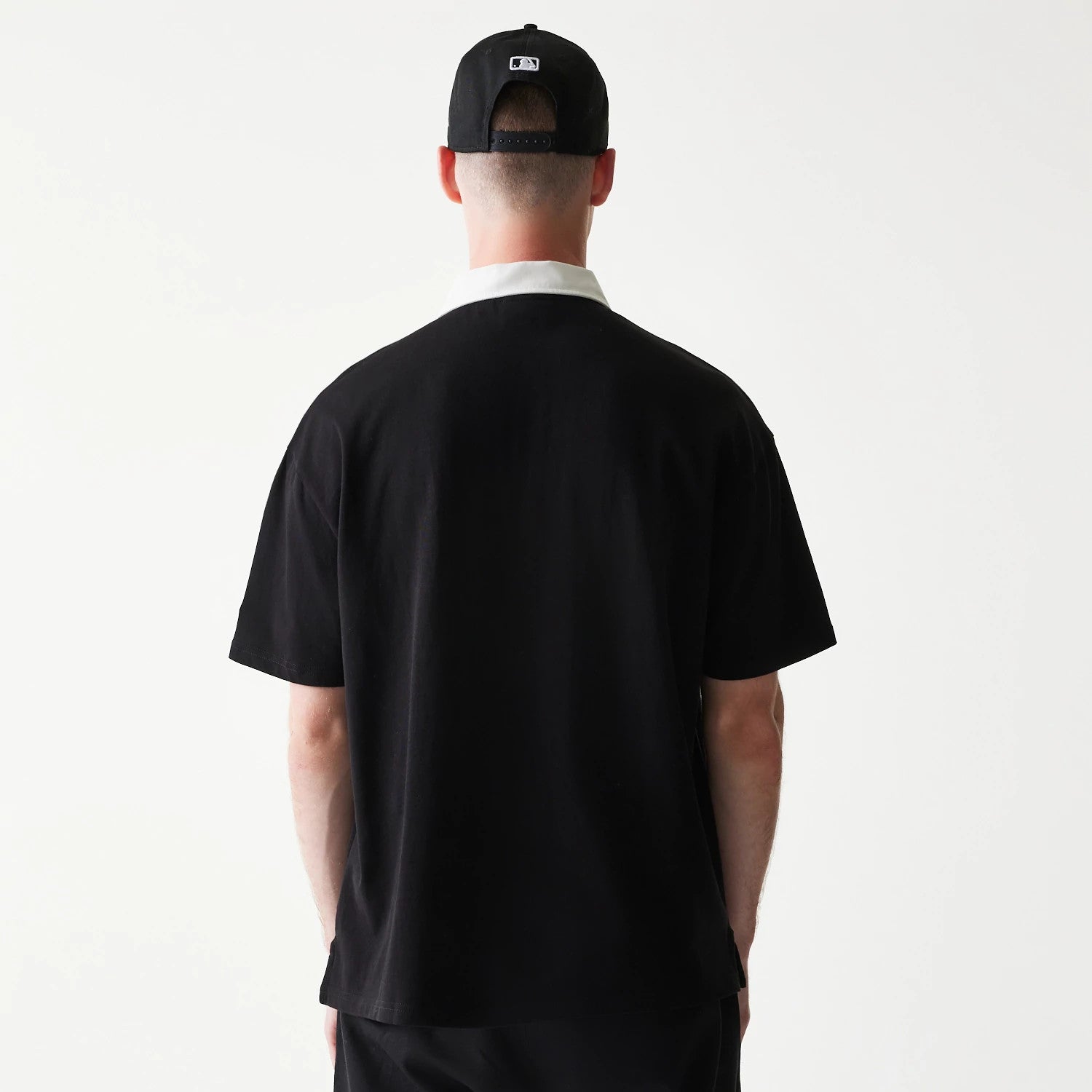 The model is wearing this MLB New York Yankees Oversized Polo T-Shirt in black. 2