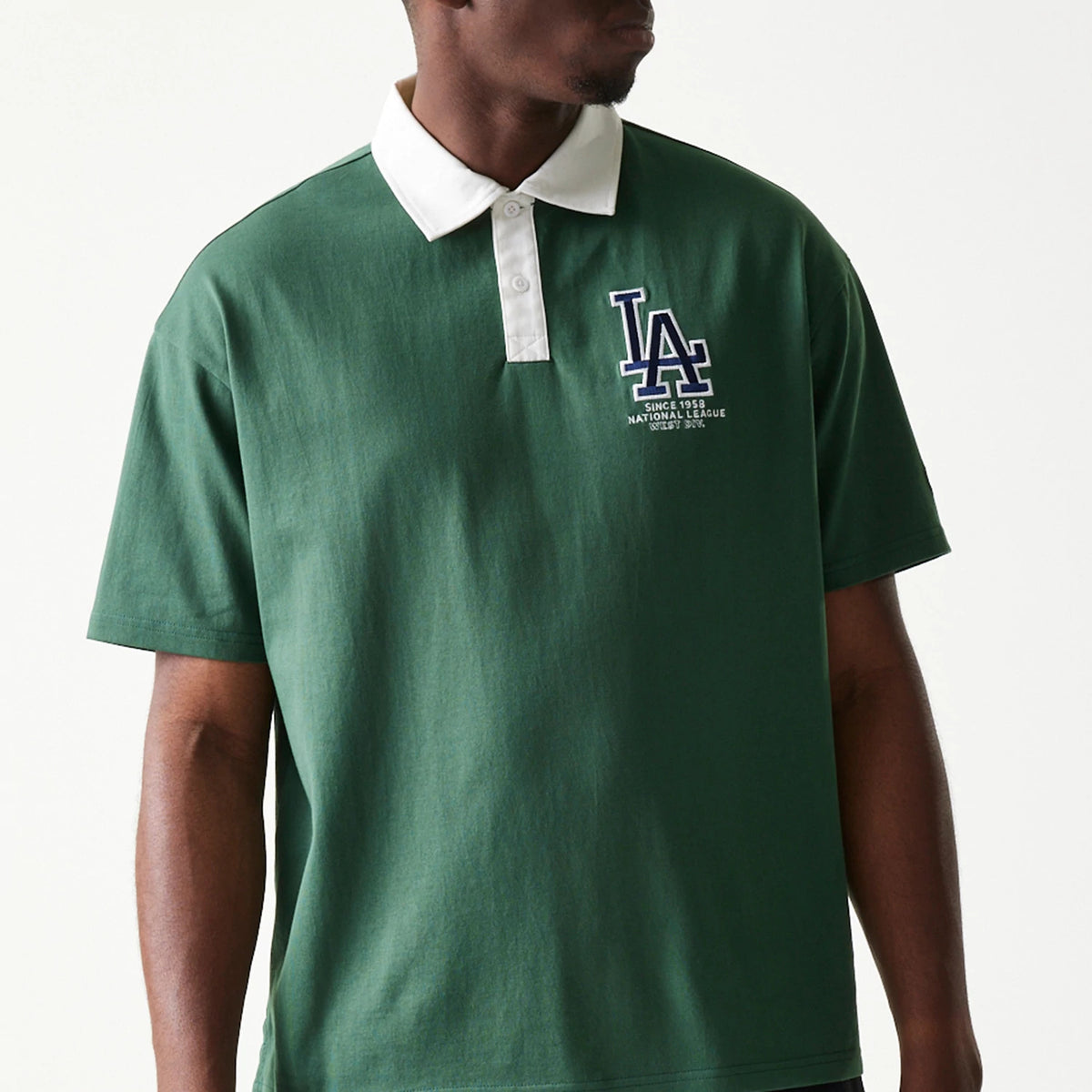 New Era LA Dodgers MLB Dark Green Oversized Polo T-Shirt, front view on a model showing an embroidered LA Dodgers logo on the left chest, with a contrasting white collar and a half button placket.