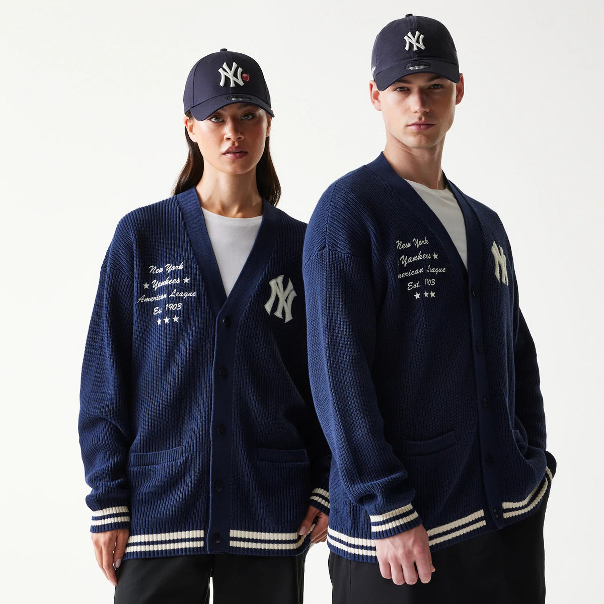 New Era New York Yankees MLB Collegiate Navy Cardigan, front view on a model showing detailed white script embroidery with New York Yankees and year established, complemented by matching striped cuffs and hem.