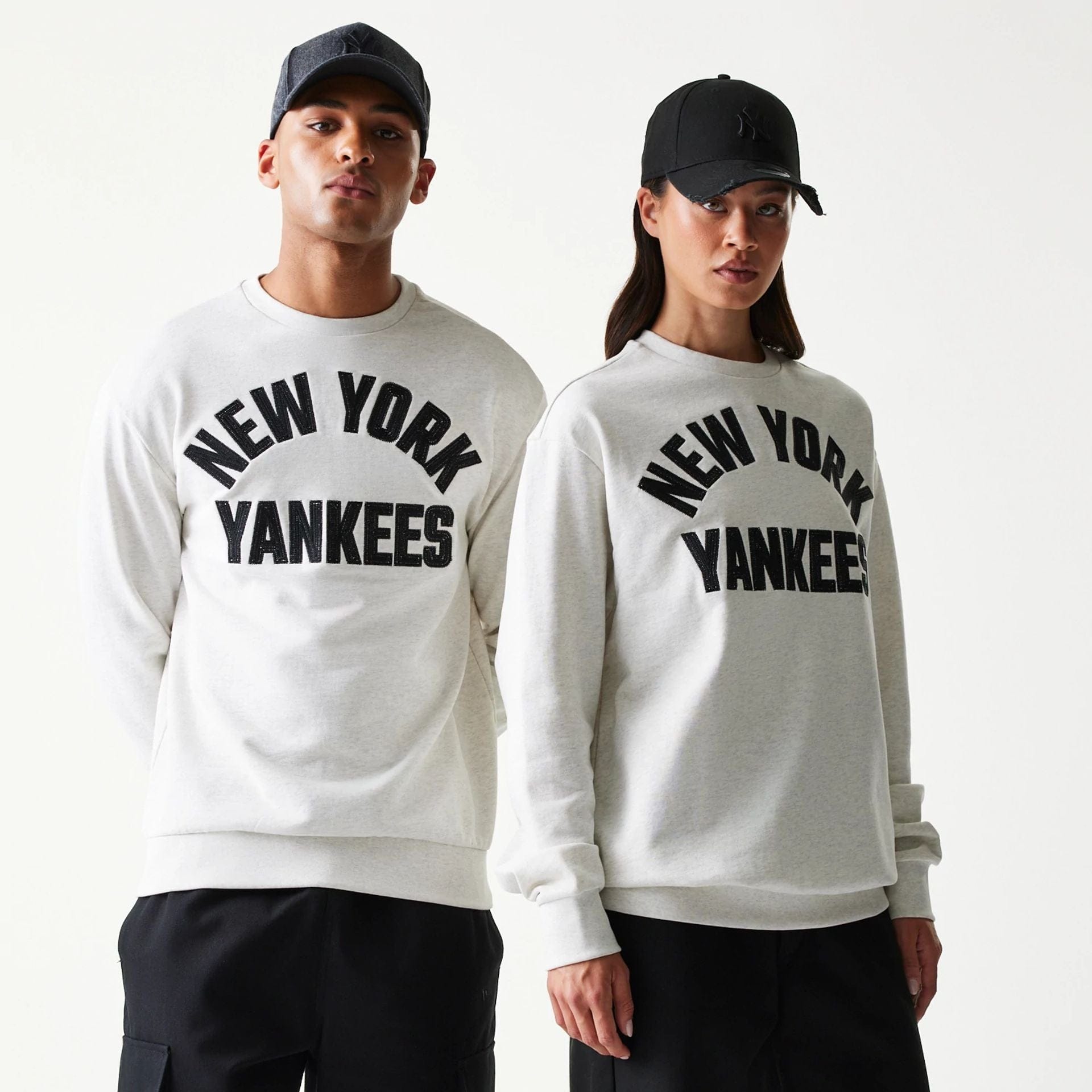 The model is wearing this MLB Graphic New York Yankees Oversized Crew Neck Sweater in pastel grey. 1