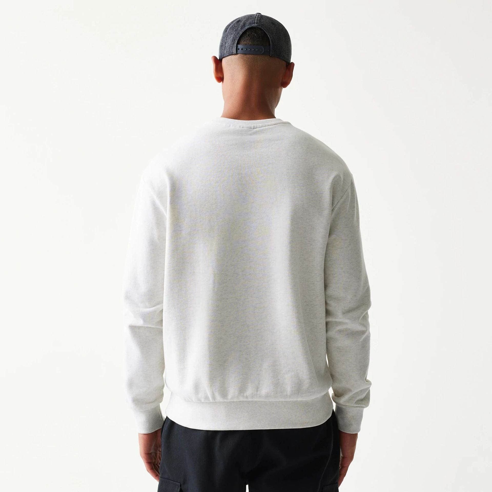 The model is wearing this MLB Graphic New York Yankees Oversized Crew Neck Sweater in pastel grey. 2