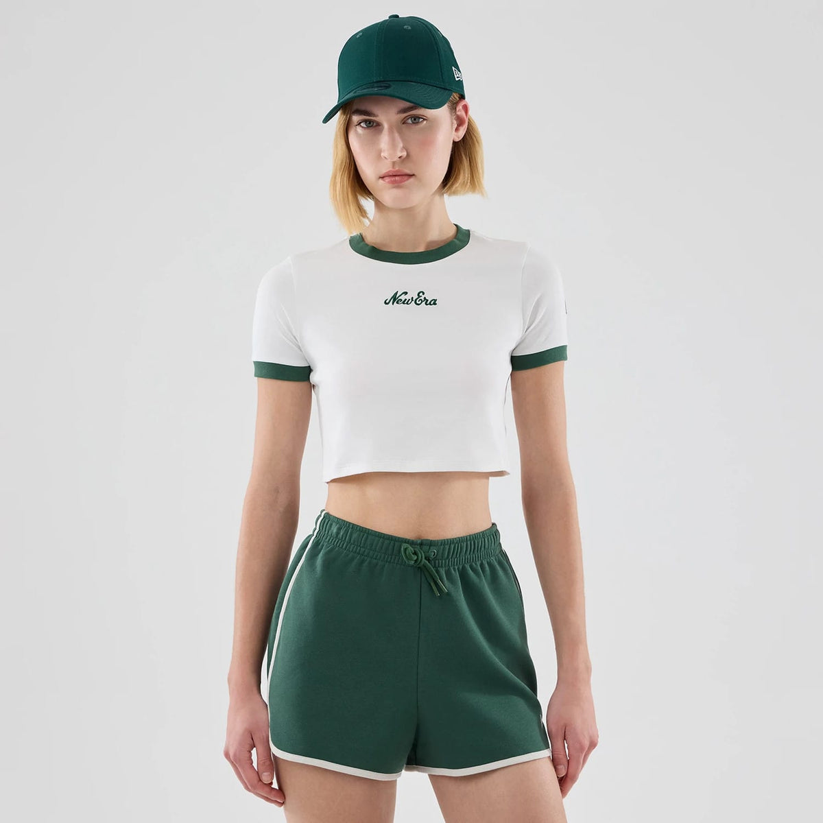 The model is wearing this Womens New Era Cropped Slim T-shirt in white. 1