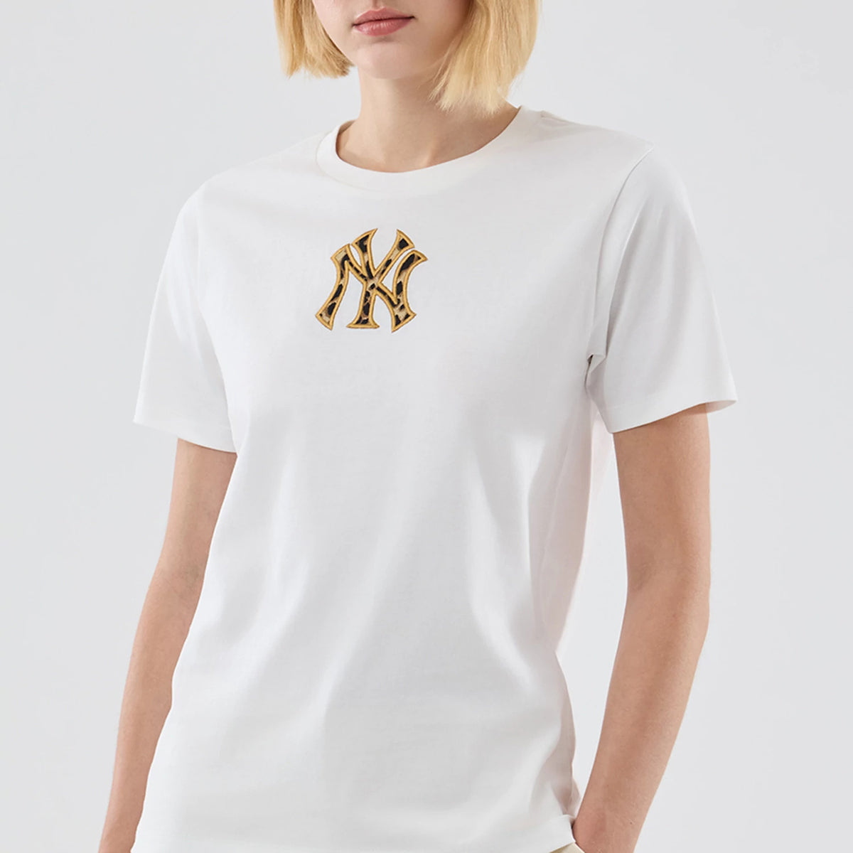 New Era New York Yankees Womens MLB Infill White T-shirt, front view on a model showing a distinctive raised NY logo with a colourful pattern on the left chest of the plain white shirt.