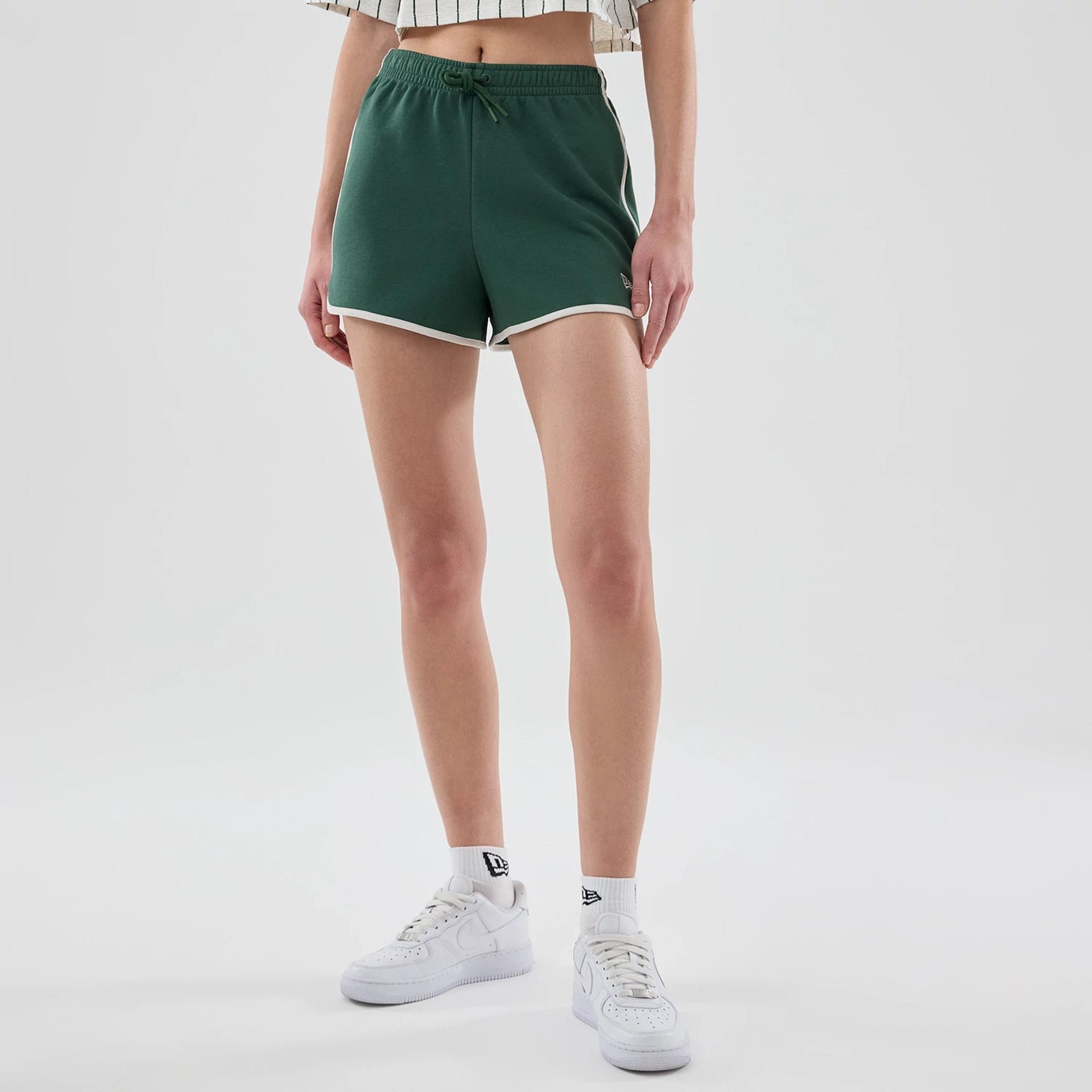 The model is wearing this Womens New Era Track Shorts in dark green. 1