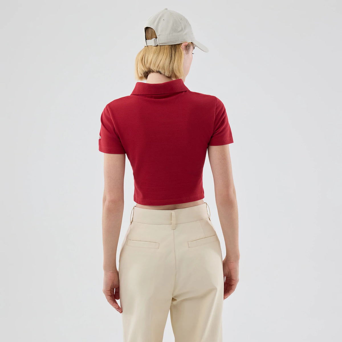 New Era New York Yankees Womens MLB Dark Red Cropped Slim Polo T-shirt, back view on-model showing the cropped hemline and short sleeves with an embroidered Yankees logo on the left arm.