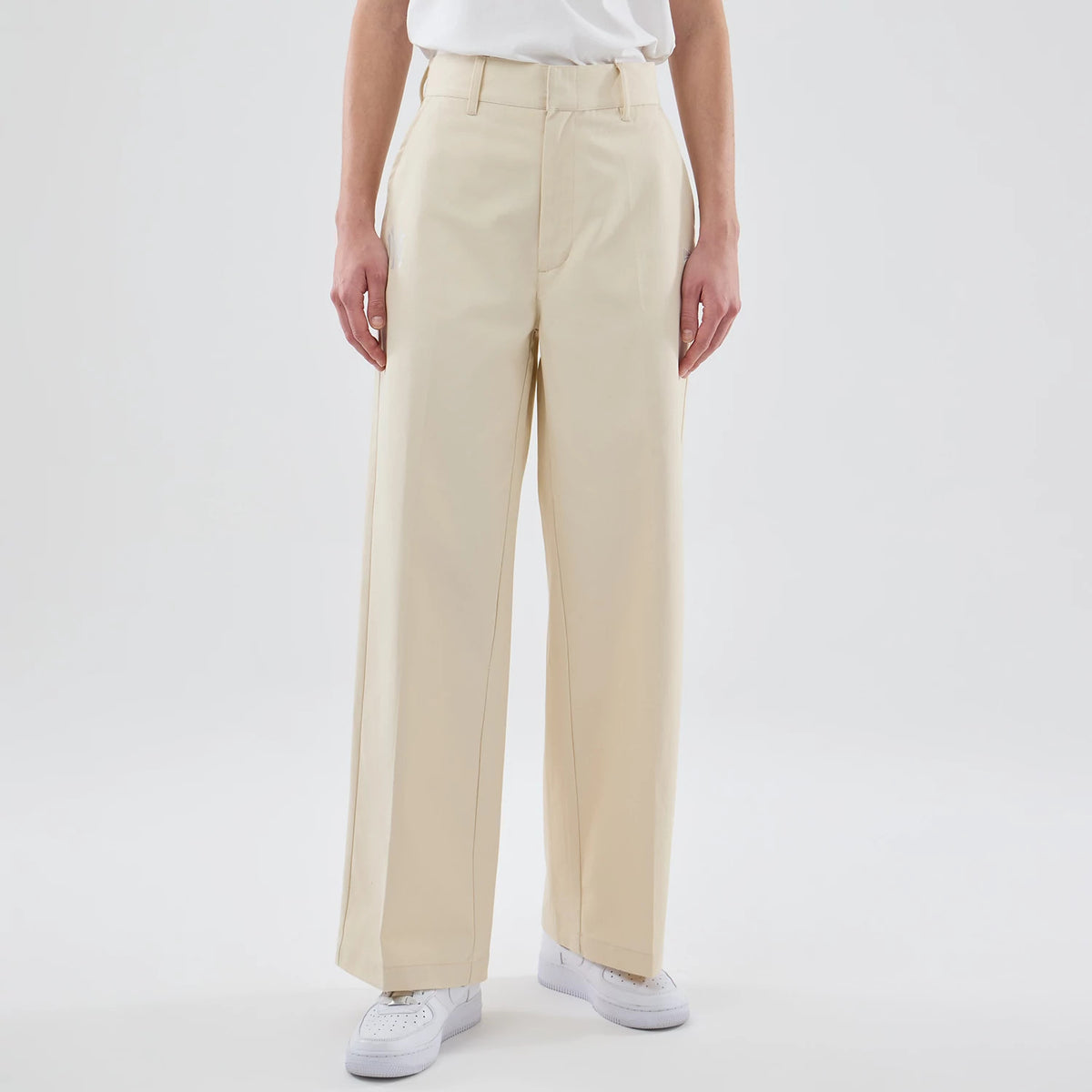 New Era New York Yankees Womens MLB Cream Chino Trousers, front view on a model showing high-waisted trousers with belt loops, a zip fly, and wide-legged design, paired with white trainers and a tucked-in white top.