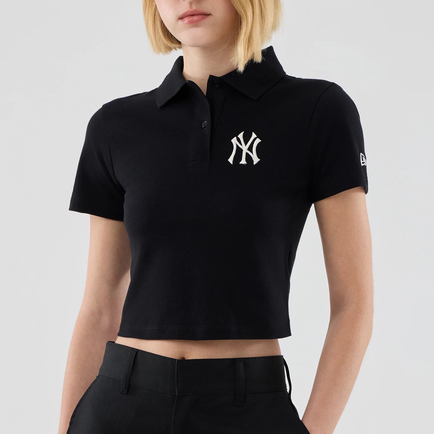 The model is wearing this Womens MLB New York Yankees Cropped Slim Polo T-shirt in black. 3
