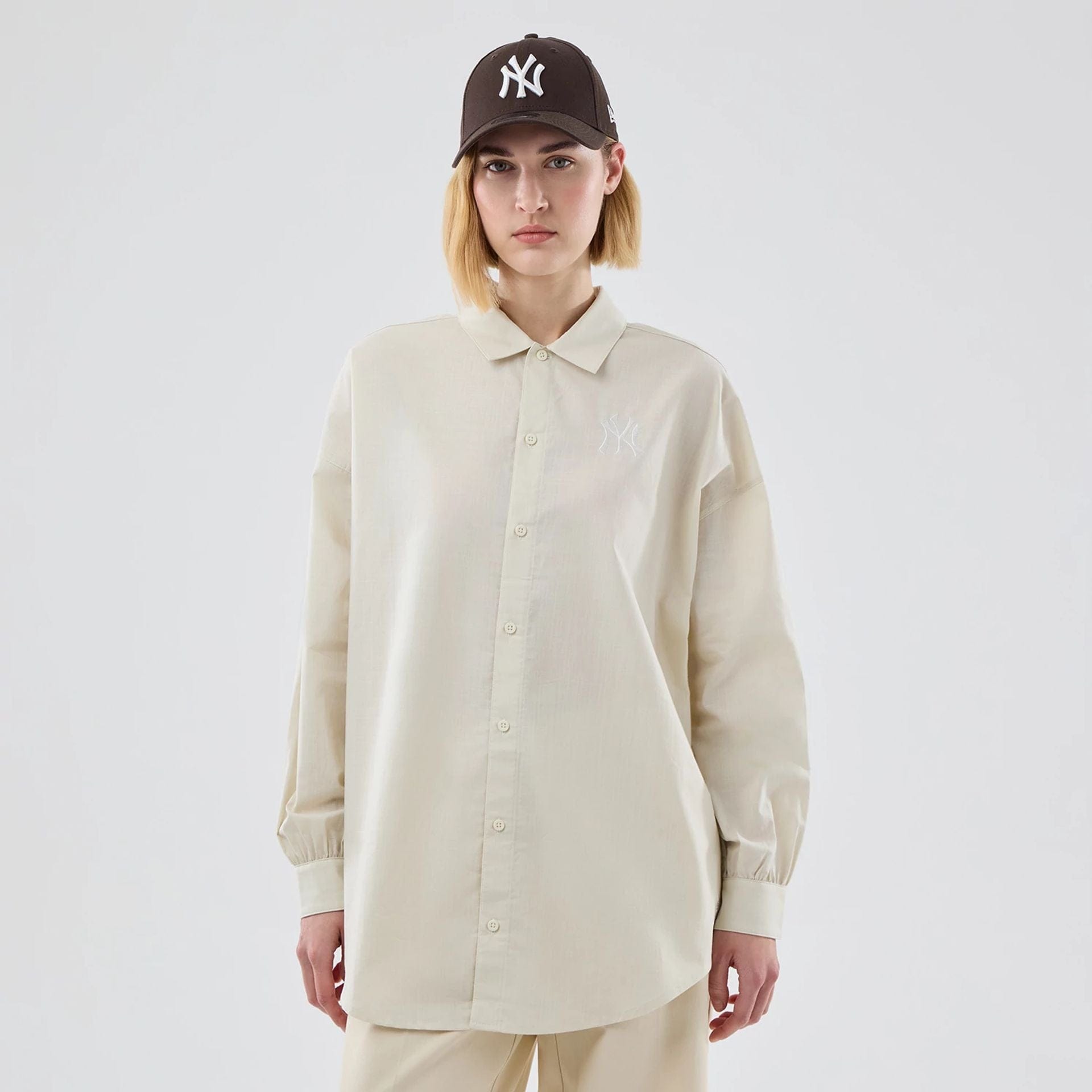 The model is wearing this Womens MLB Shirt New York Yankees Long Sleeve Shirt in cream. 1