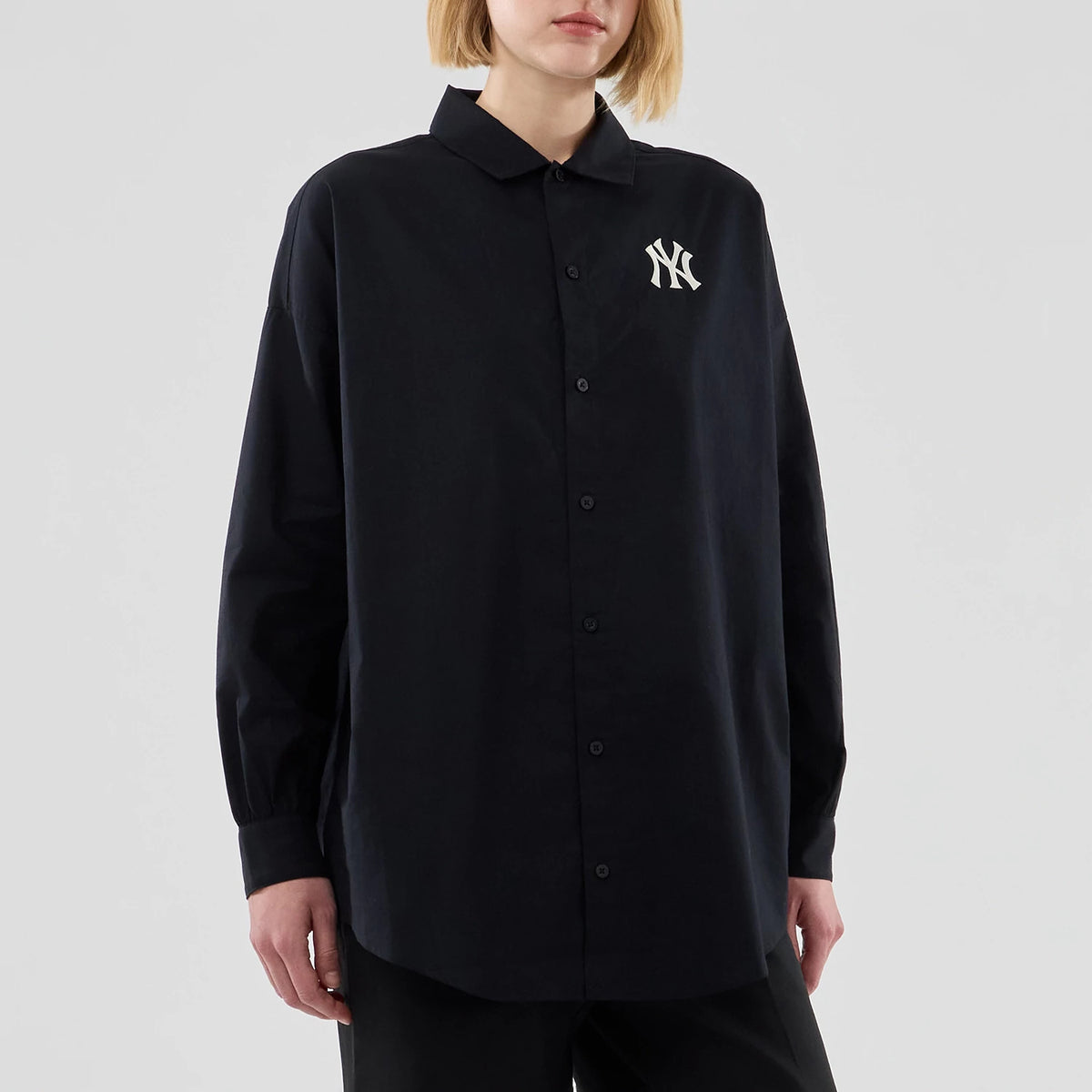 New Era New York Yankees Womens MLB Shirt Black Long Sleeve Shirt, front view on a model showing the white NY logo embroidered on the left chest, with a button-down front and classic collar in a loose fit style.