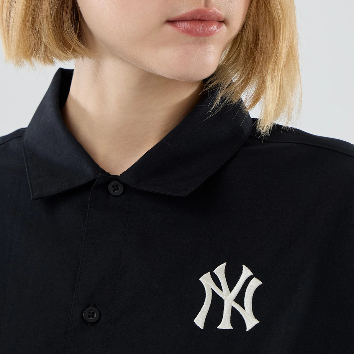 New Era New York Yankees Womens MLB Shirt Black Long Sleeve Shirt, front view showing a close-up of the white embroidered NY logo on the left chest, with a traditional collar and black buttons on the placket.