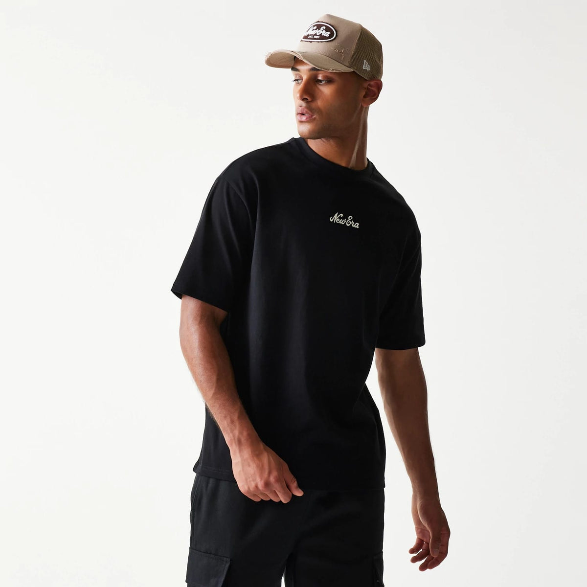 The model is wearing this New Era Heritage Script T-Shirt in black. 8